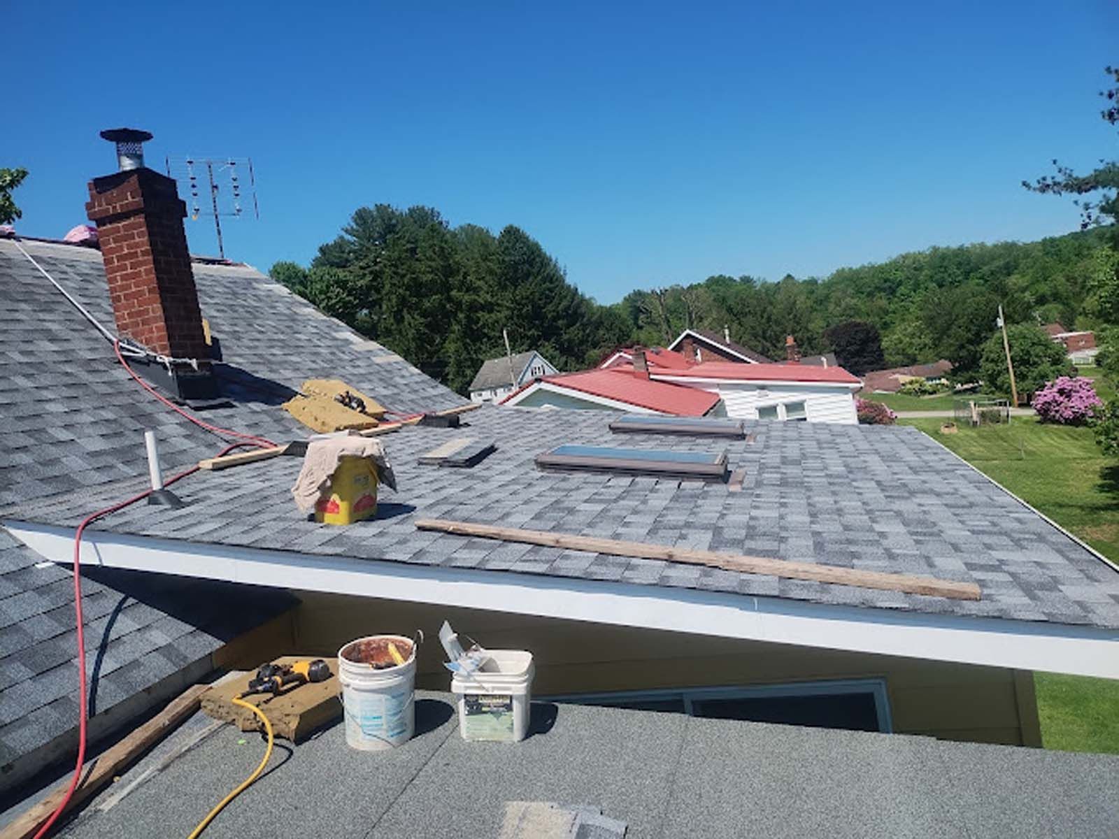 A roof with a chimney and a bucket of paint on it