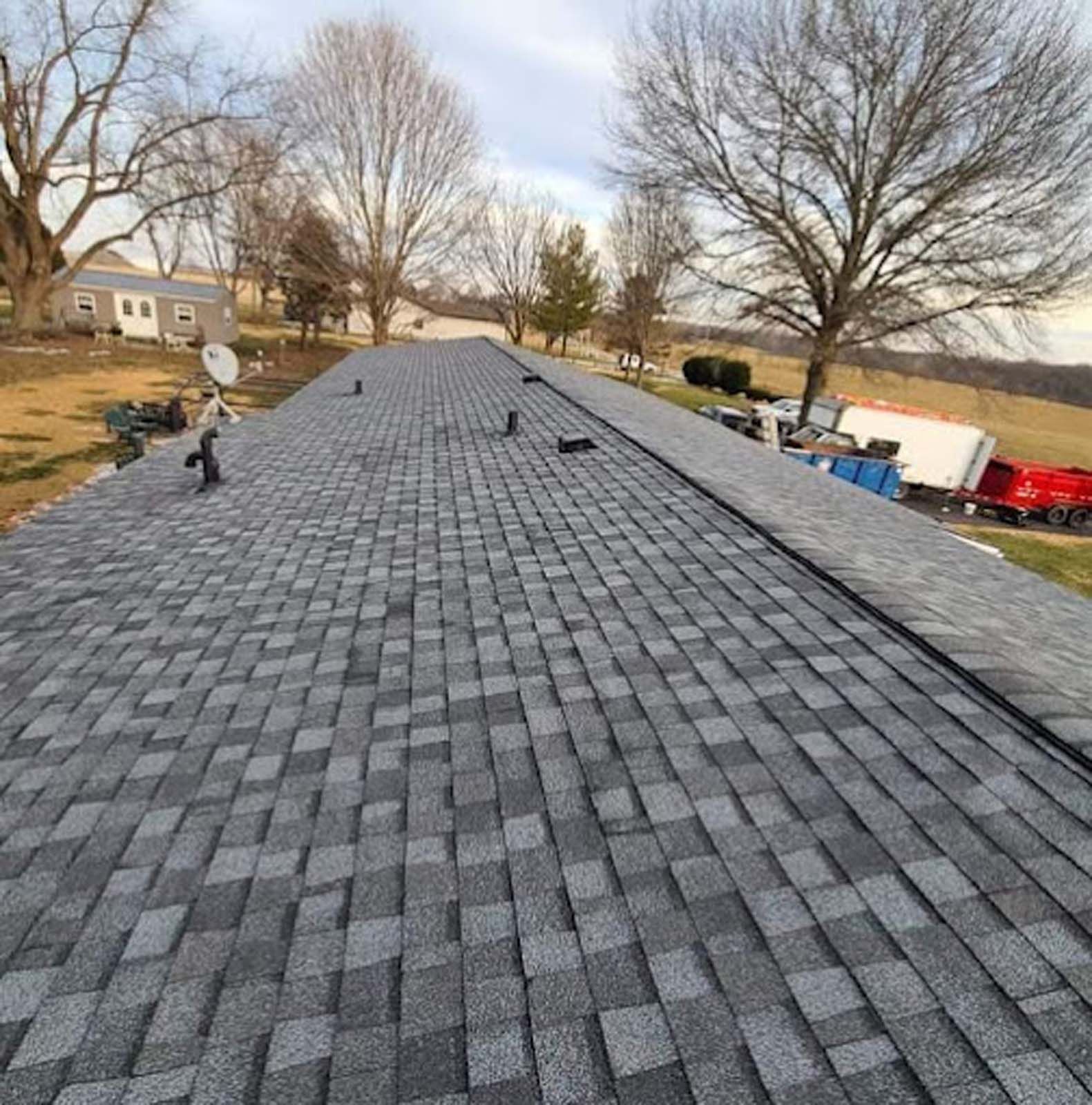 The roof of a house with a satellite dish on it.