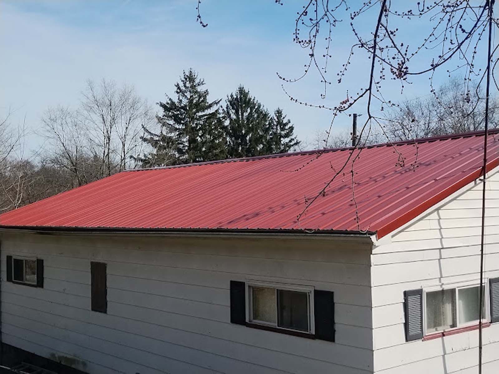 A white house with a red roof and black shutters