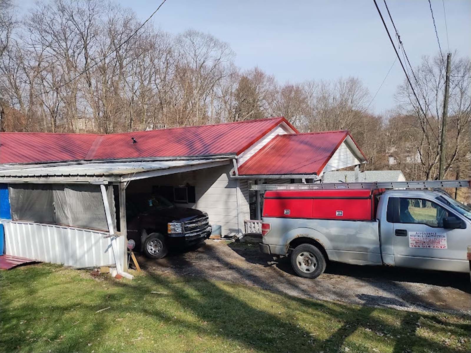 A truck is parked in front of a house with a red roof.