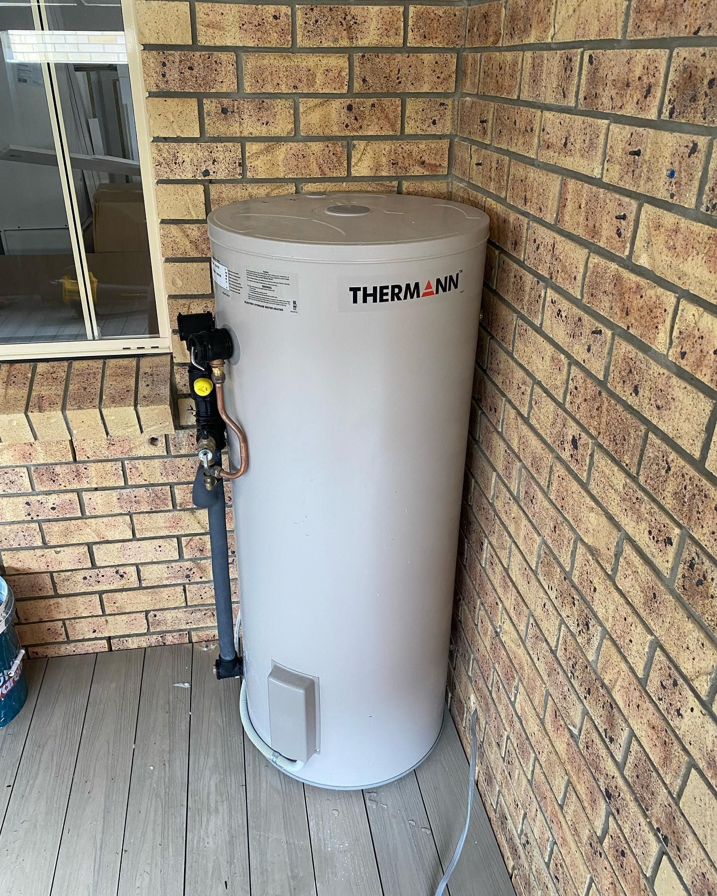 Tall Beige Hot Water Heater Against a White Wall — C’s Plumbing & Gas Gold Coast in Yatala, QLD