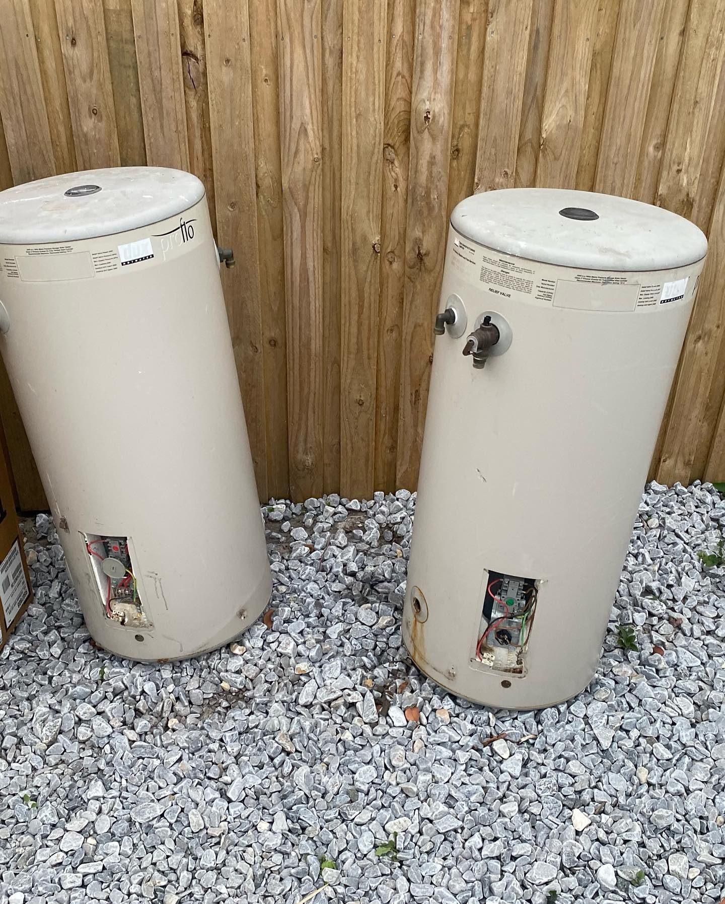 Two Beige Cylindrical Water Heaters on Gravel — C’s Plumbing & Gas Gold Coast in Yatala, QLD