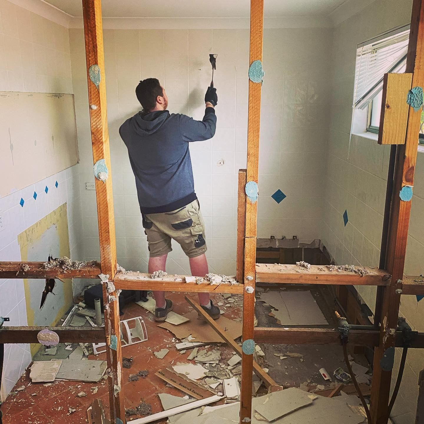 Man in Shorts Renovating a Room With a Tool — C’s Plumbing & Gas Gold Coast in Logan, QLD
