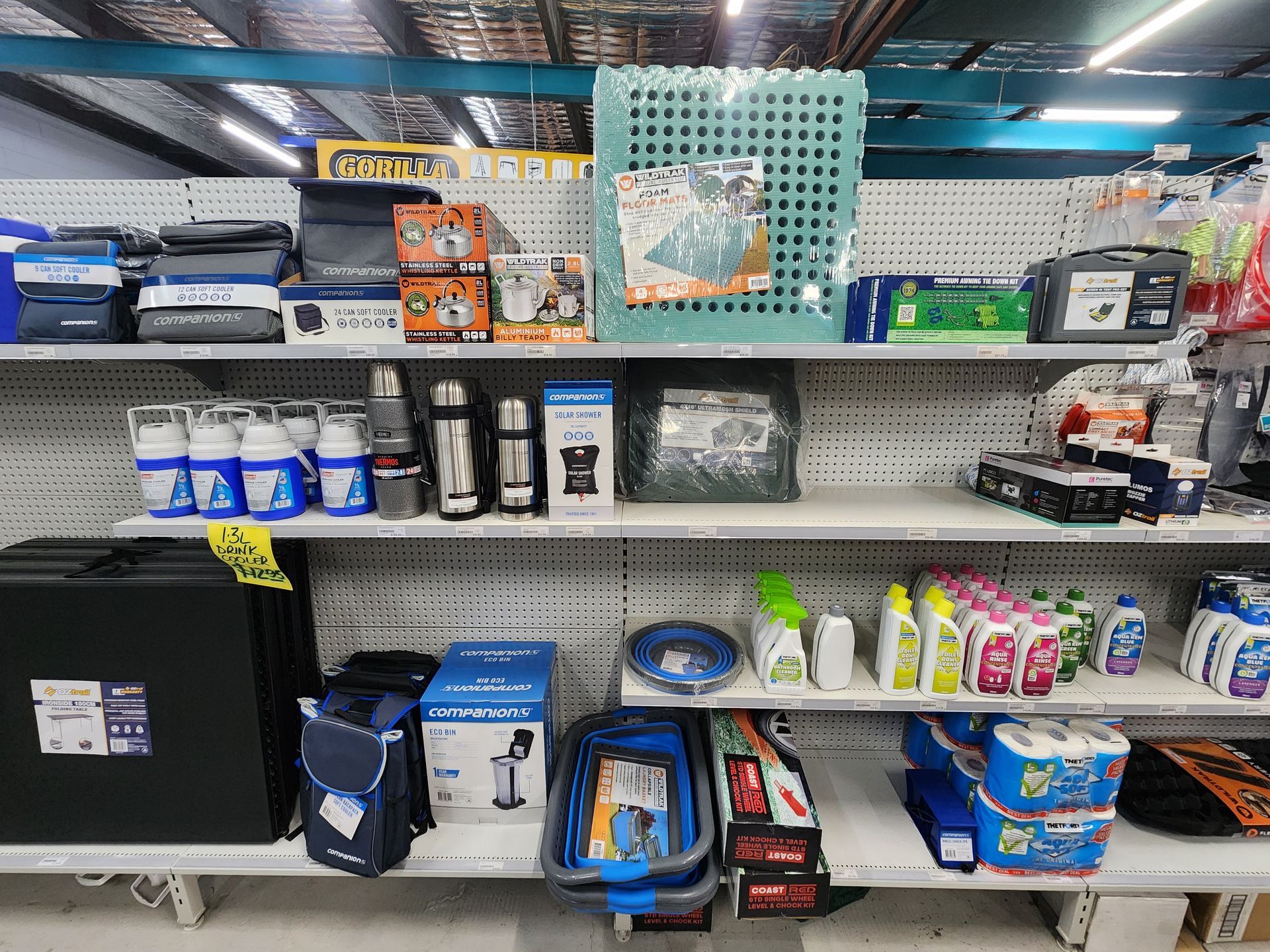 Shelves stocked with various camping and cleaning supplies.