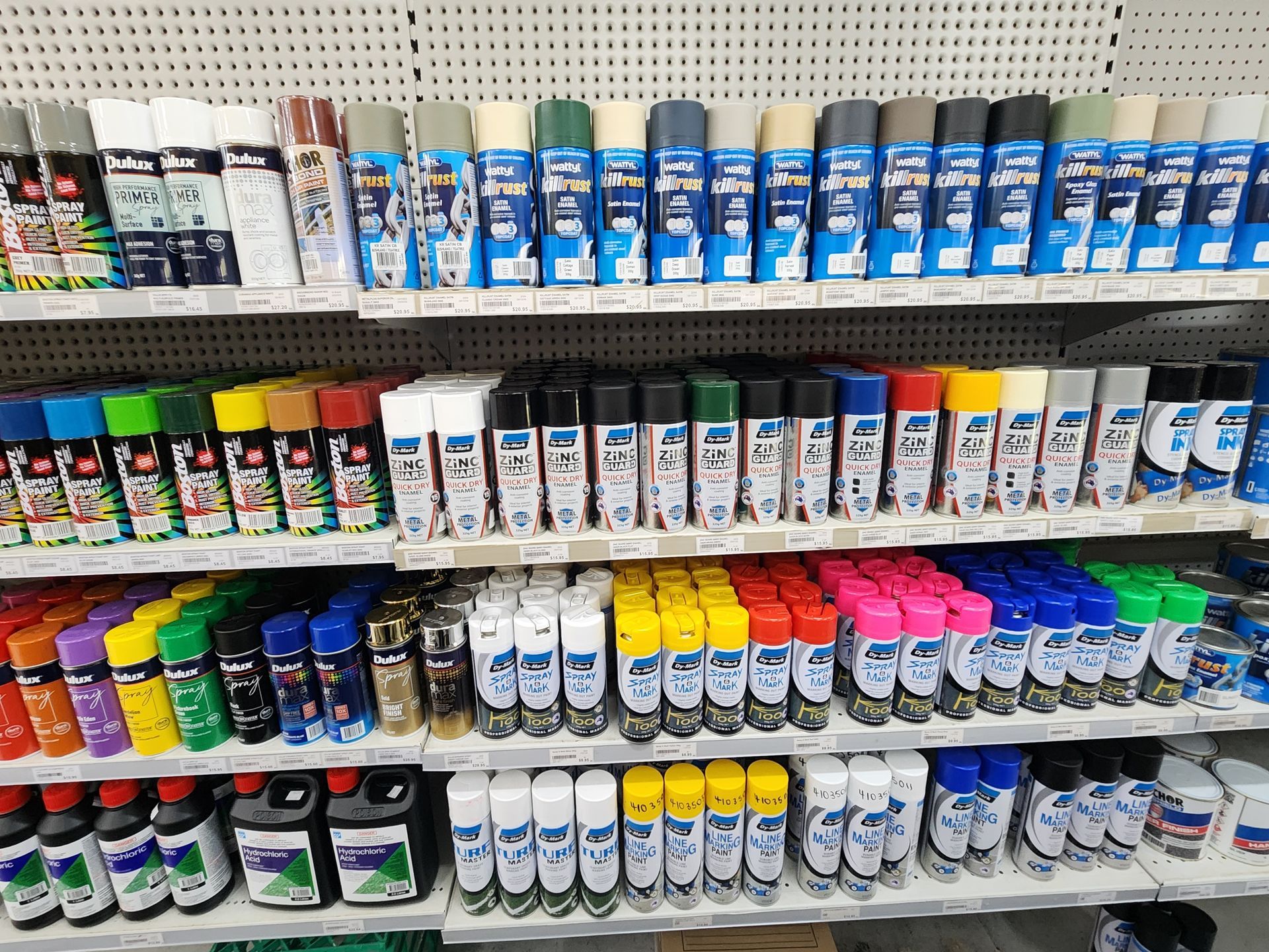 Shelves stocked with various spray paint cans in a retail setting; an array of colors are visible.