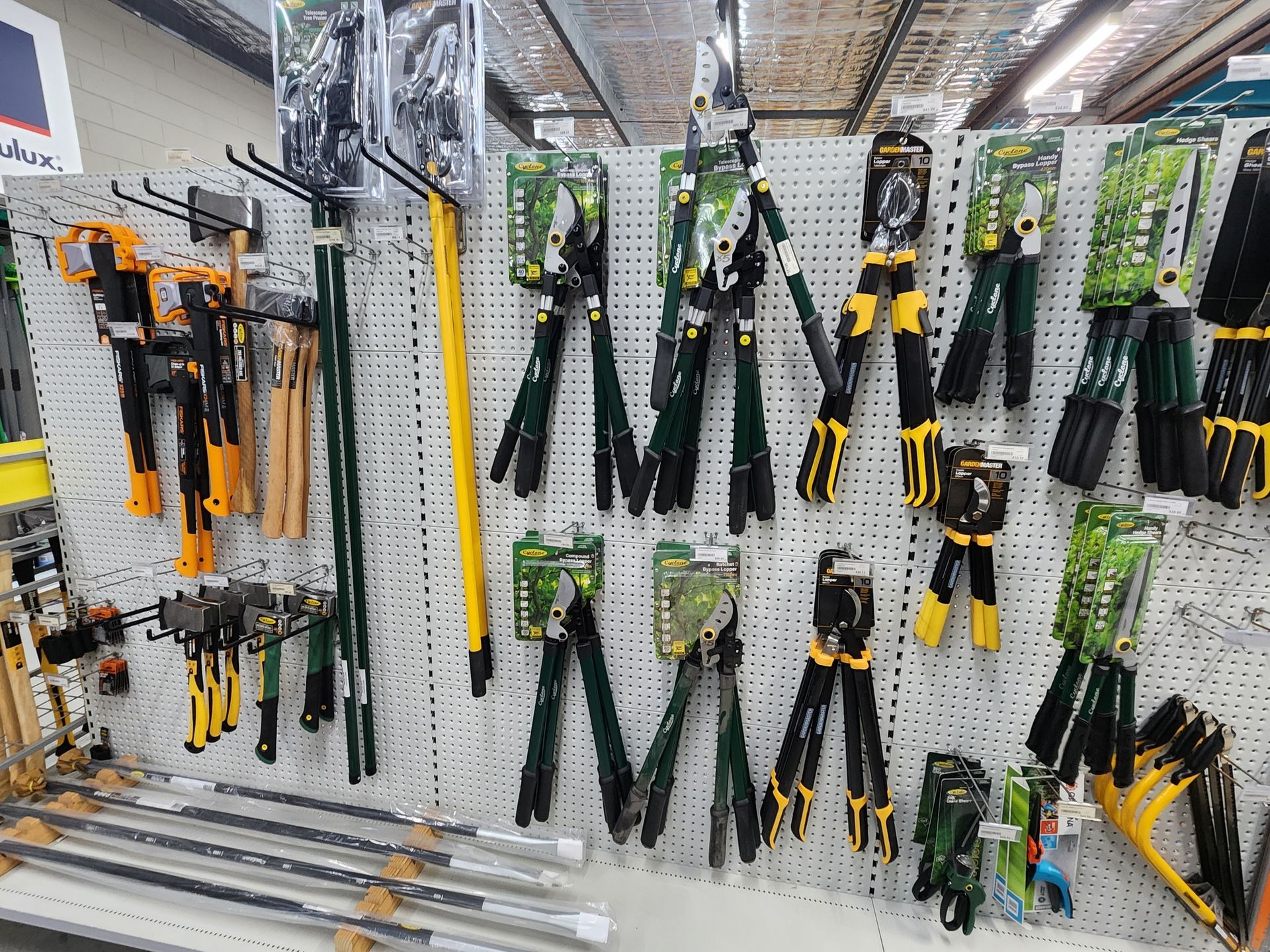 Garden tools on display at a store, including shears, pruners, and rakes.