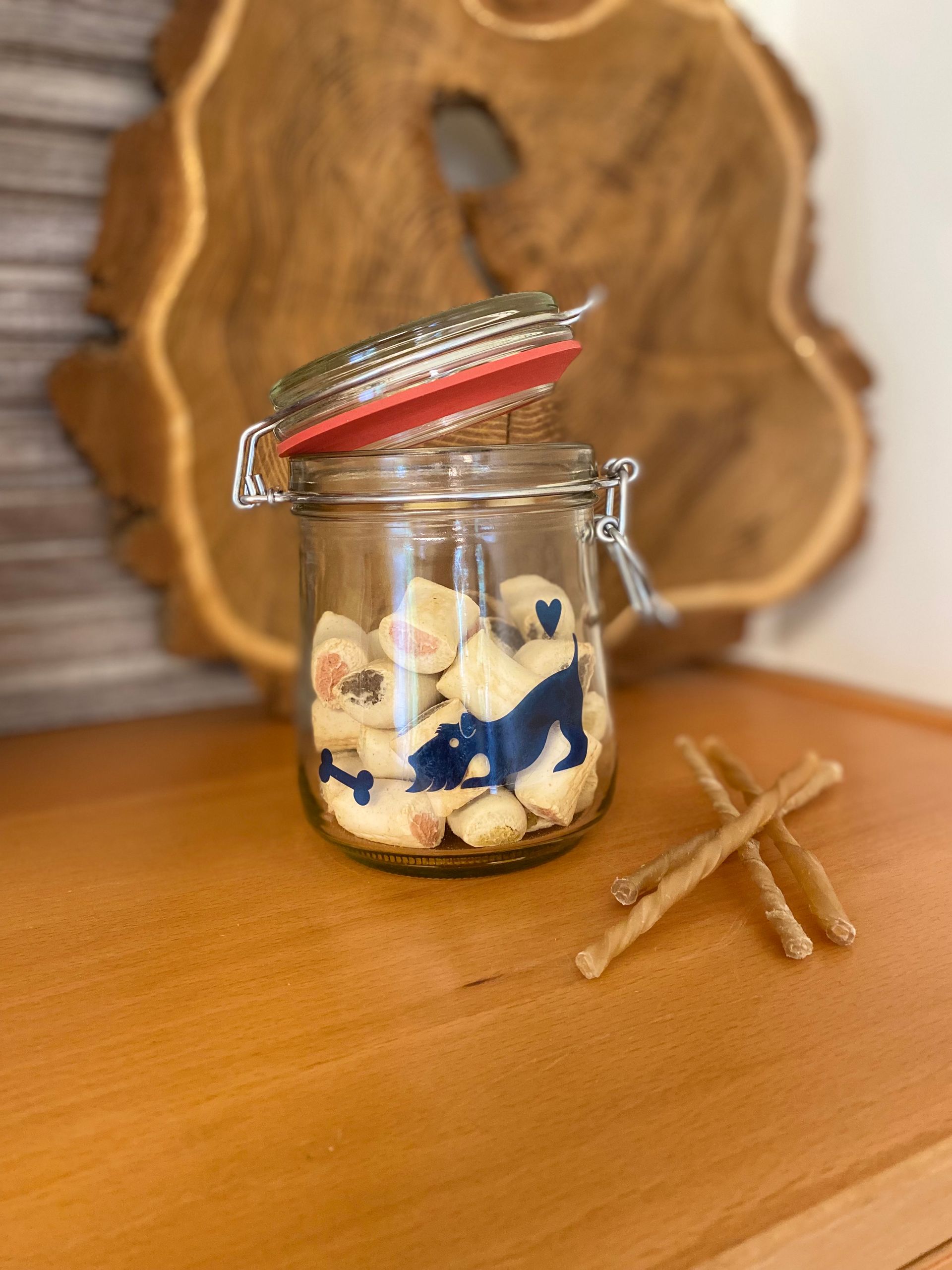 Glazen pot met rood deksel, een blauw hondensilhouet en een rood handvat.