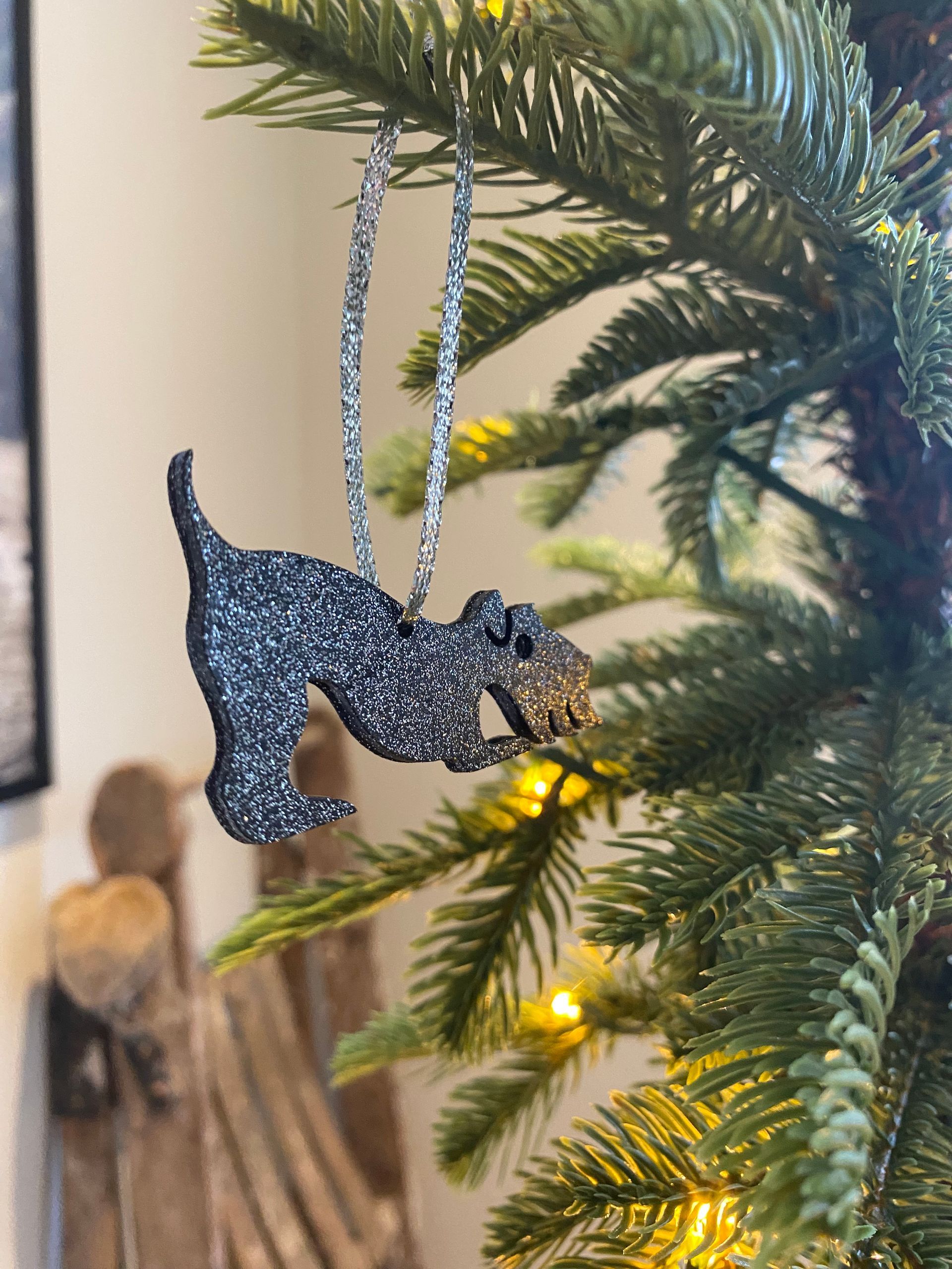 Glinsterend zwart hondenornament hangend in de kerstboom.