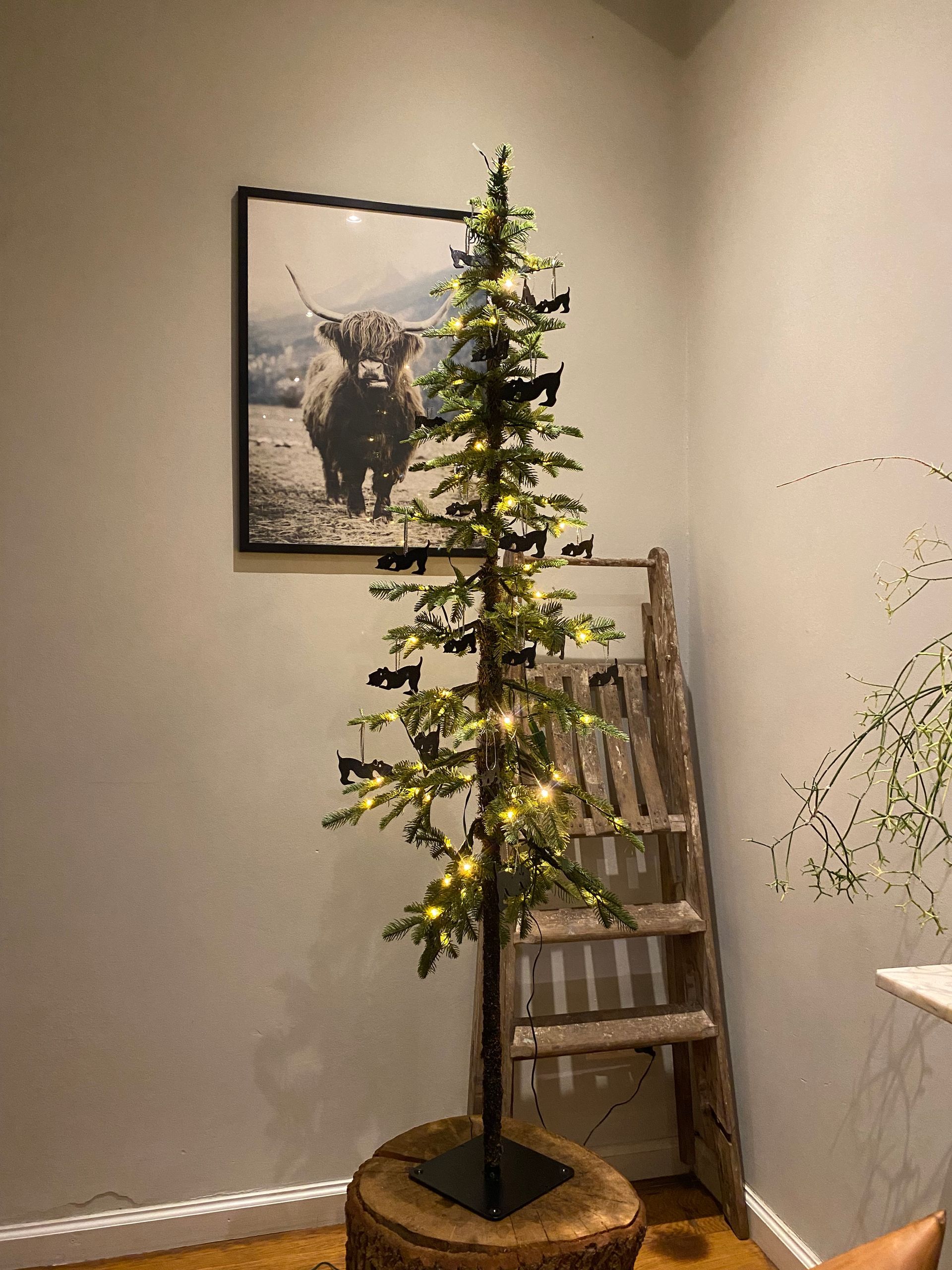 Glinsterend zwart hondenornament hangend in de kerstboom.