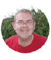 Ein Mann mit Brille und rotem Hemd lächelt in die Kamera.