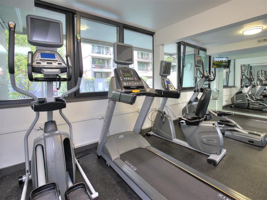 Cardio machines in a modern apartment community gym with treadmills and ellipticals.