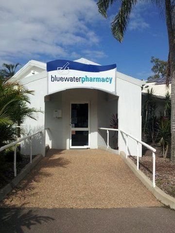A White Building With a Sign That Says Bluewater Pharmacy on It — Bluewater Pharmacy in Yabulu, QLD