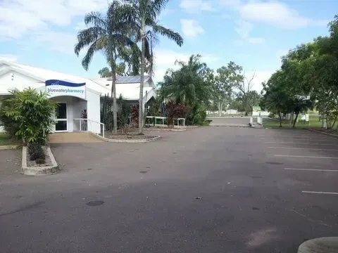 A Parking Lot in Front of a Building With Palm Trees — Bluewater Pharmacy in Yabulu, QLD