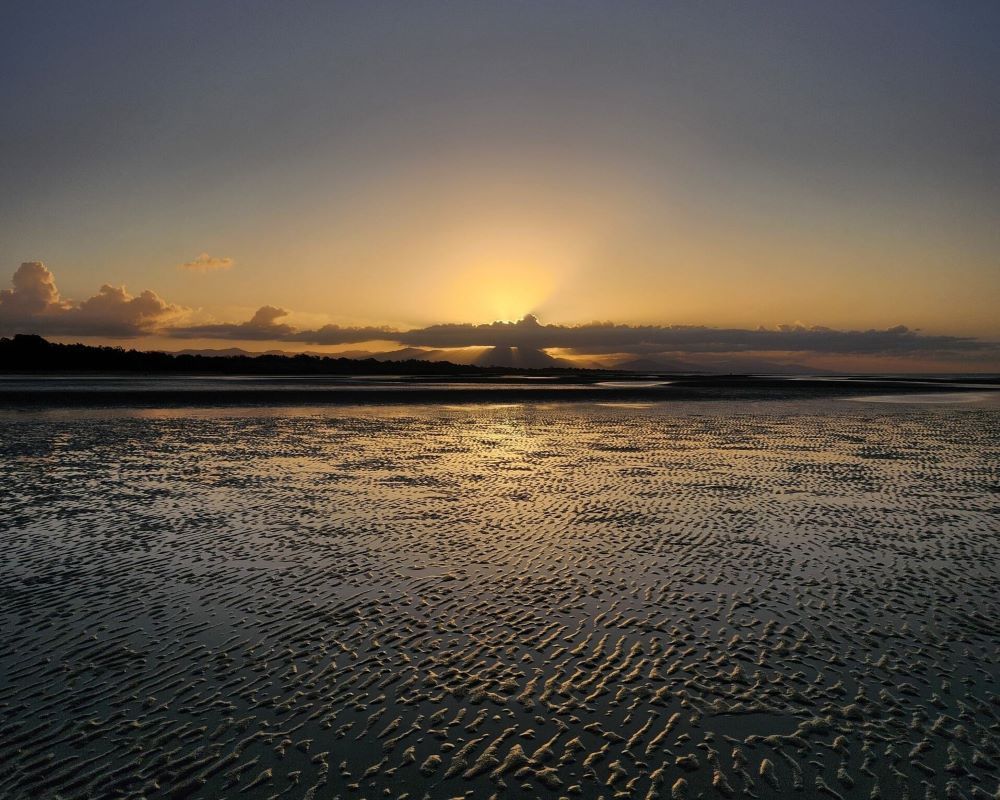 The Sun is Setting Over a Body of Water — Bluewater Pharmacy in Bluewater, QLD