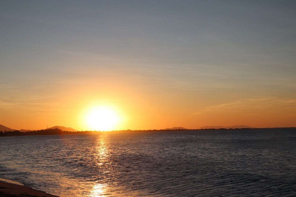 The Sun is Setting Over a Body of Water — Bluewater Pharmacy in Balgal, QLD