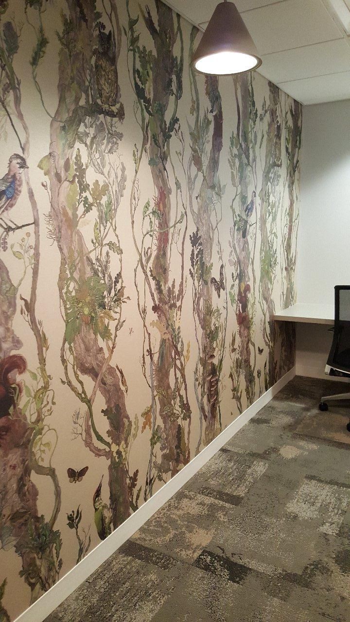 A room with a painting on the wall and a lamp hanging from the ceiling.