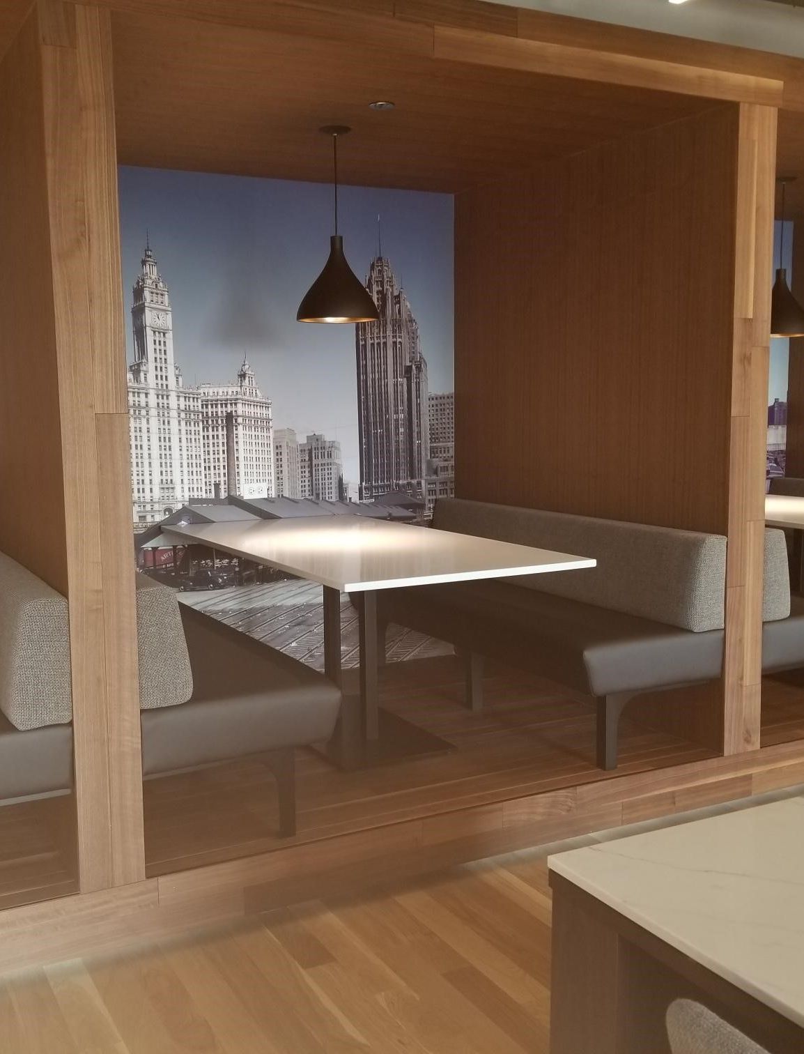 A booth with a table and a picture of a city on the wall