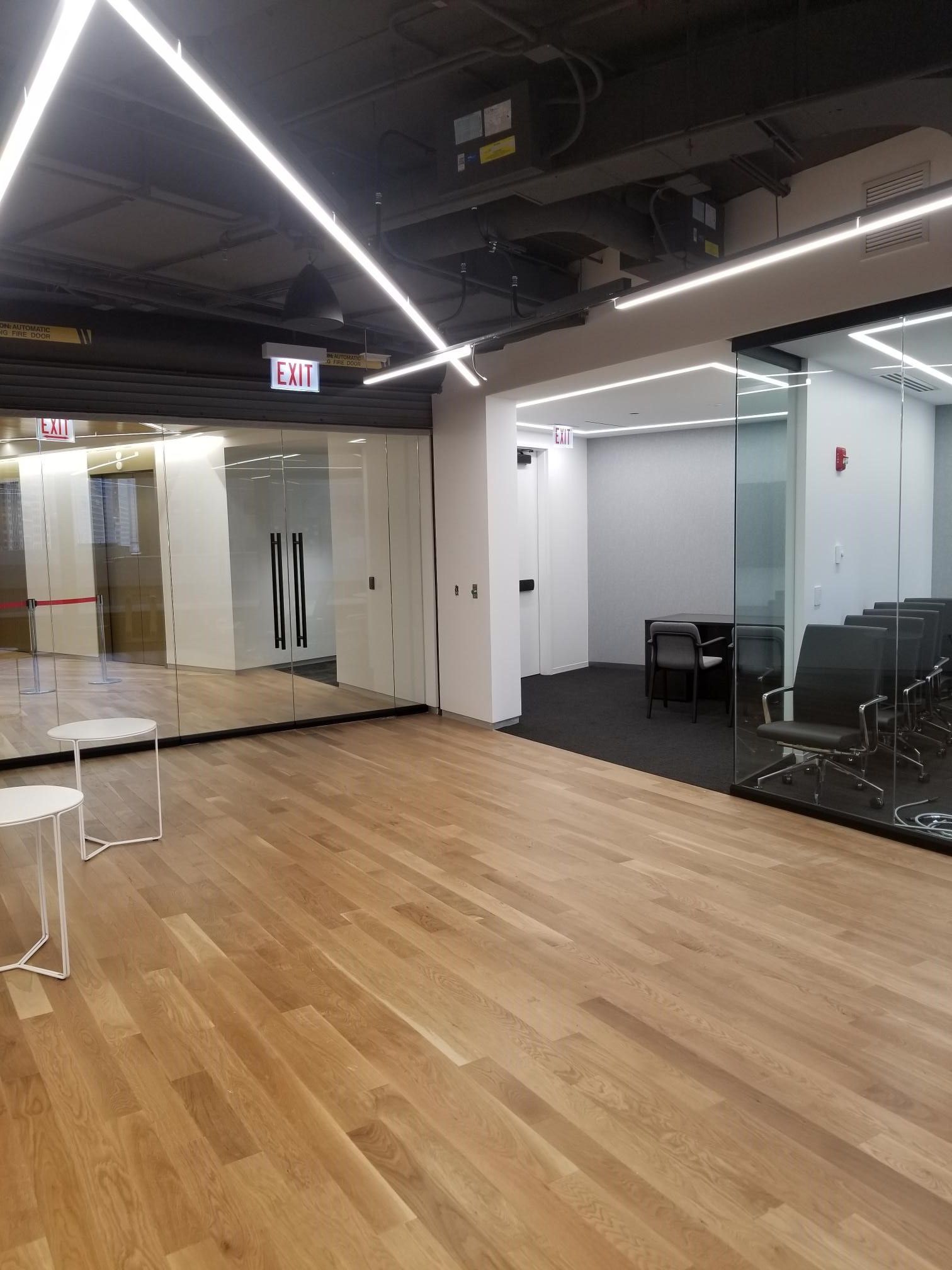 A large room with wooden floors and a mirror.