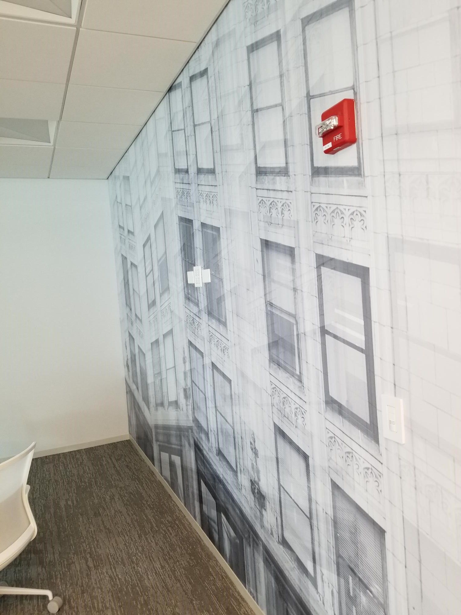 A room with a large picture of a building on the wall.