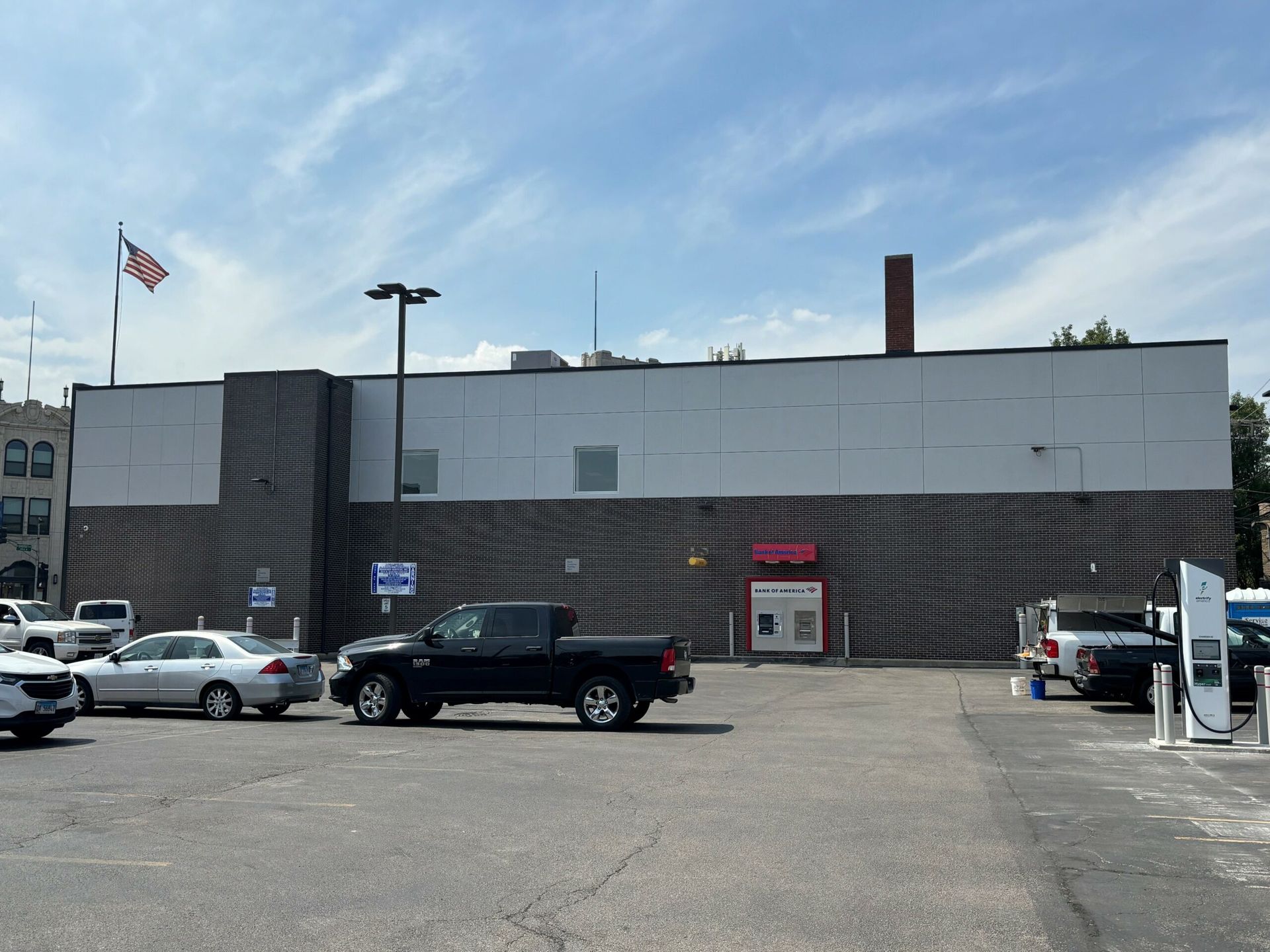 A black truck is parked in front of a large building
