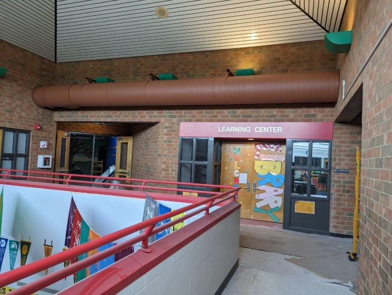 A brick building with a red sign that says learning center