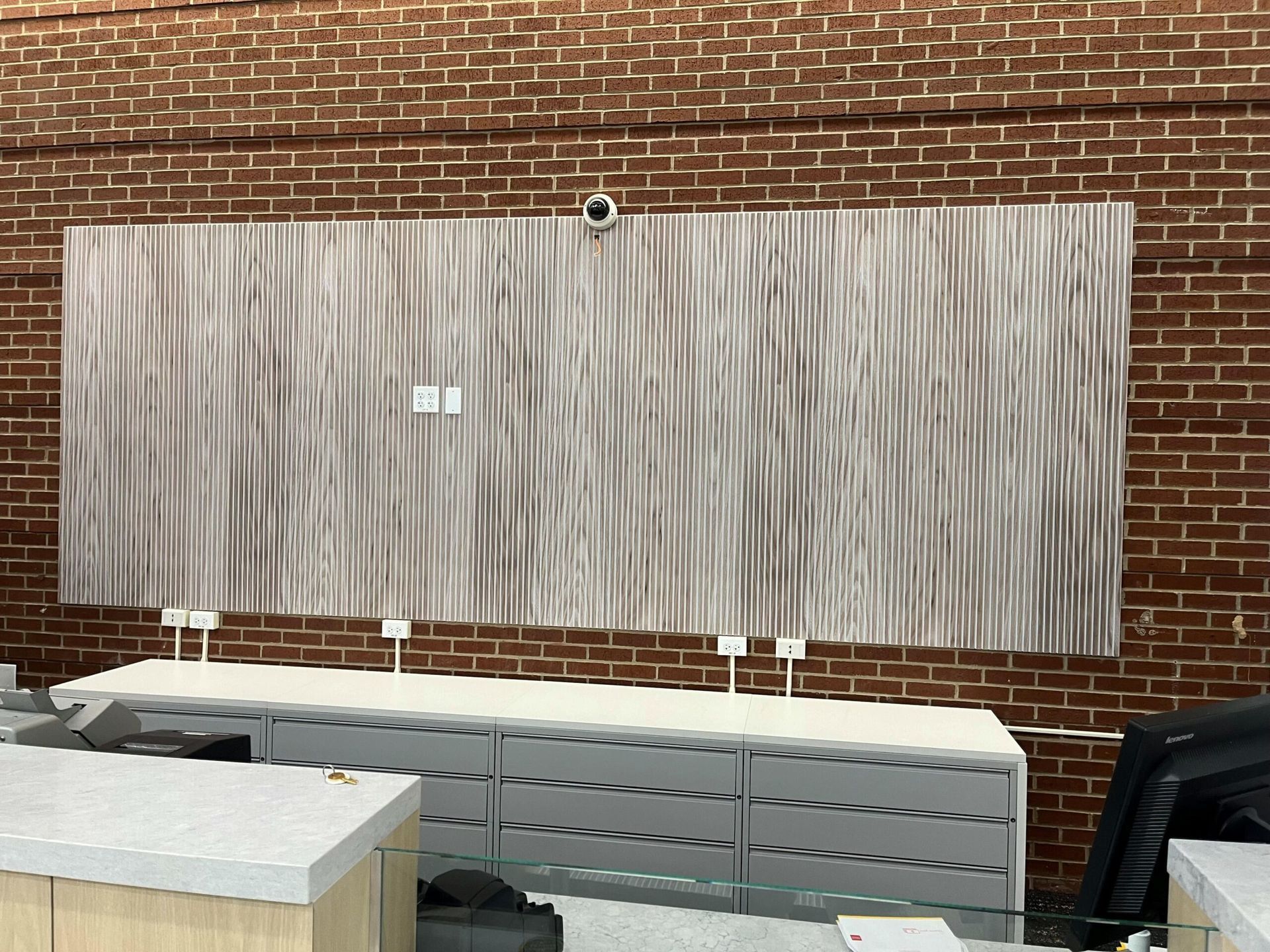 A brick wall with a large wooden panel on it