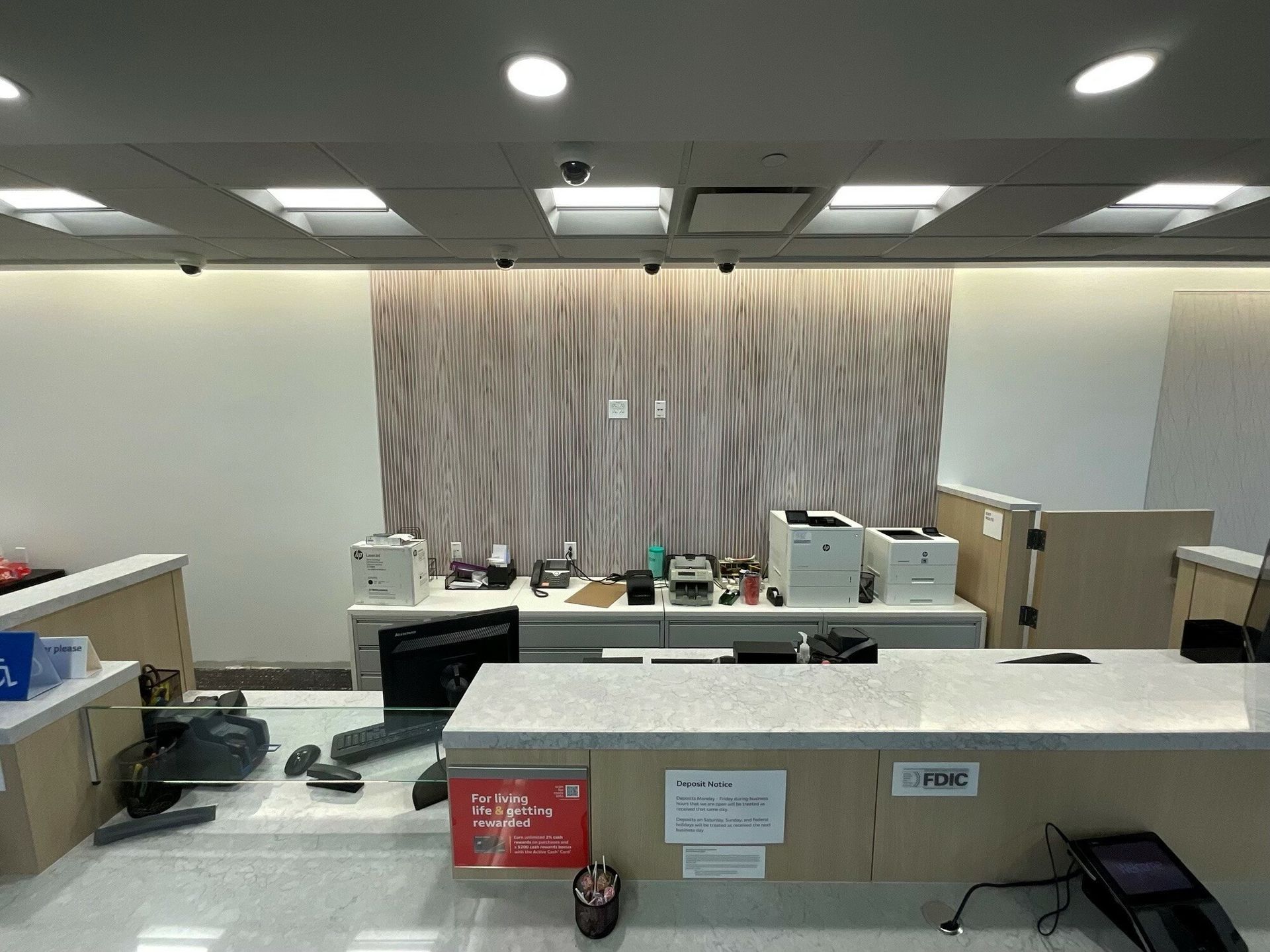 There is a counter in the middle of the room with a computer on it.