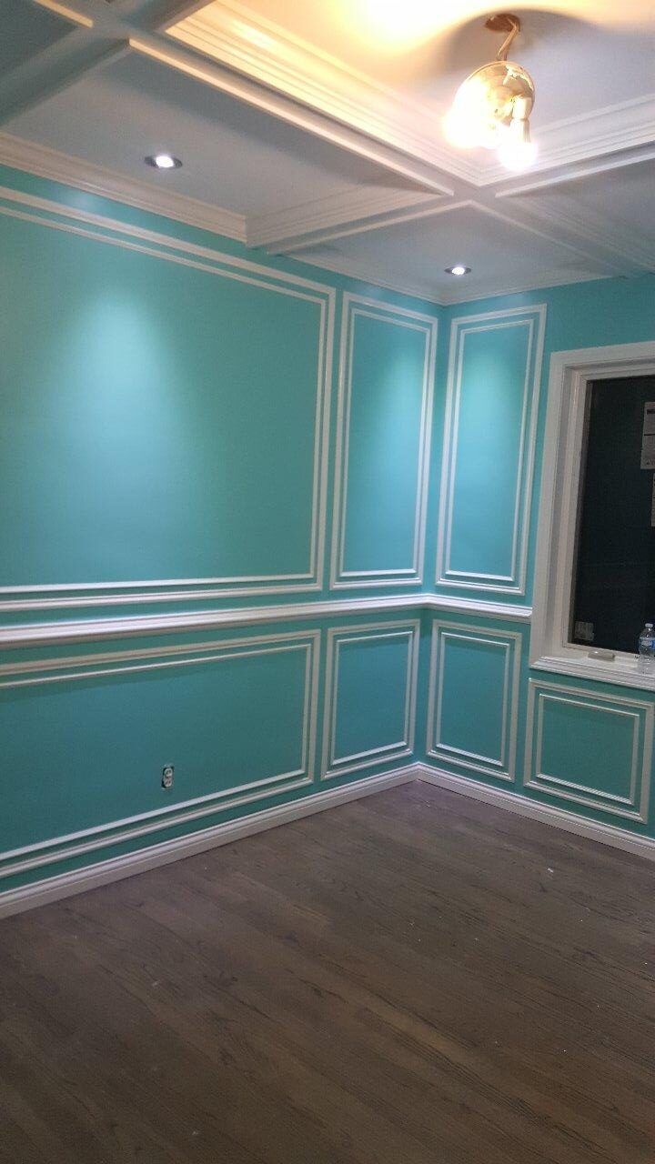 A room with blue walls and white trim and a window.