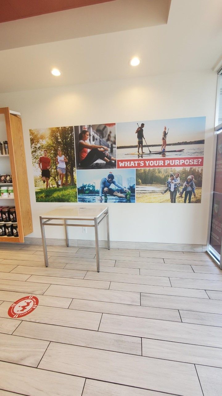 A room with a table and a picture on the wall that says what 's your purpose ?