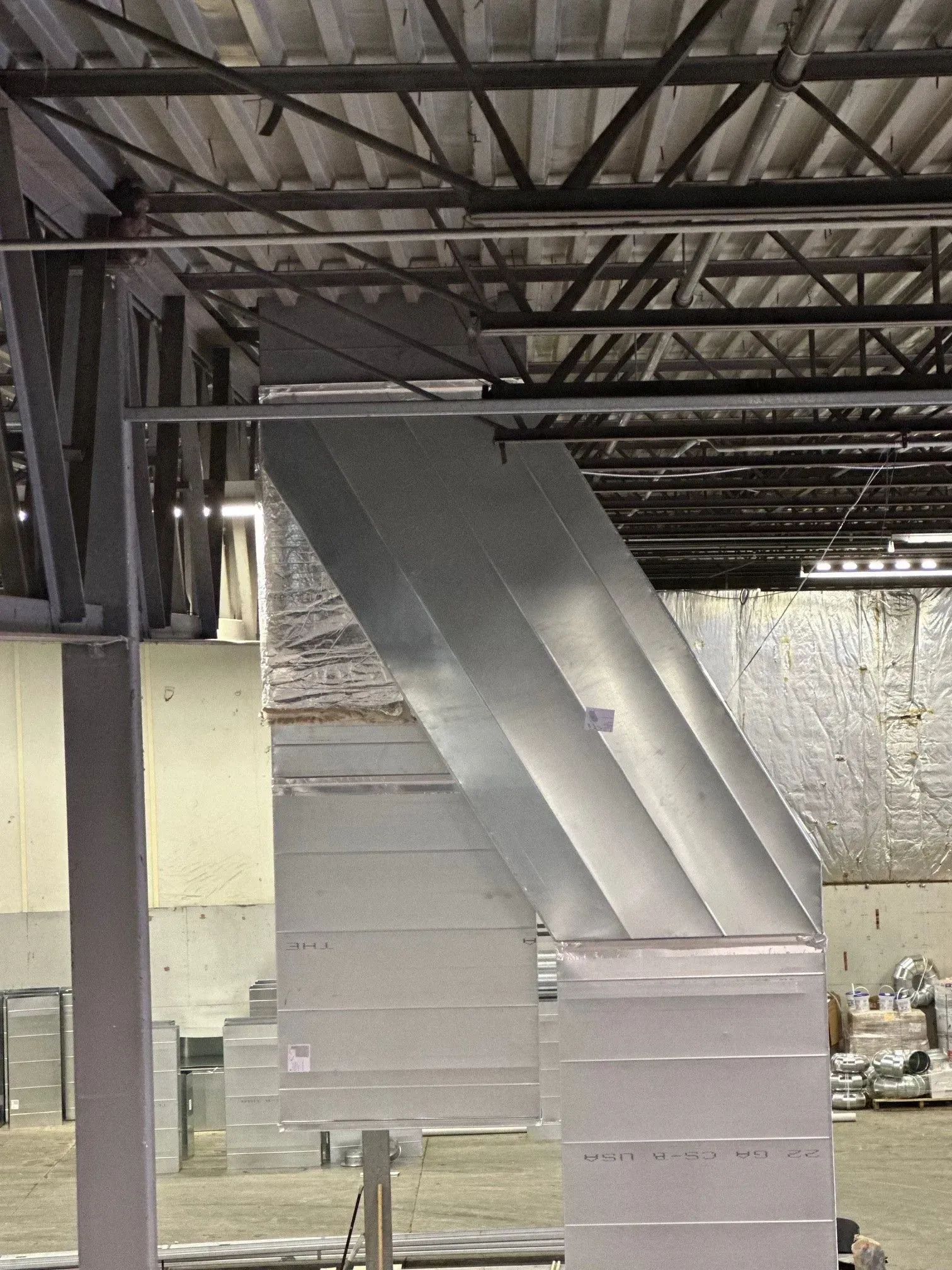 Metal HVAC ductwork installed in a commercial building ceiling, angled downwards.
