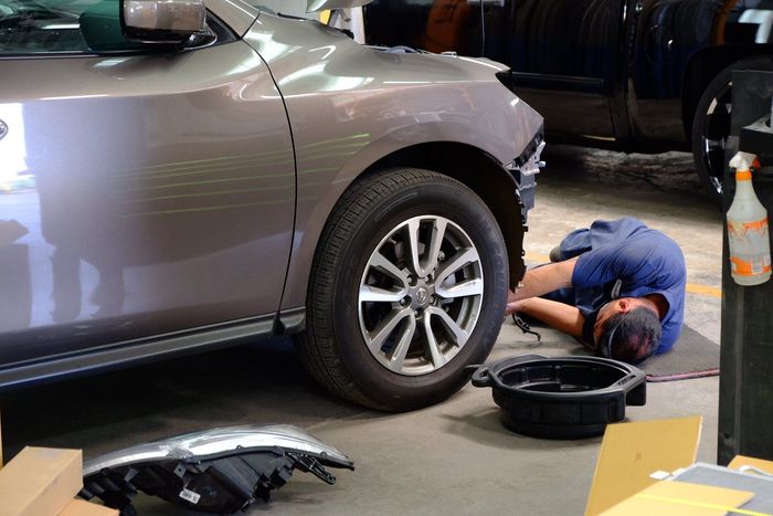 Mechanic repairing gray car — Waipahu, HI — Westside Fender/Body & Refinishing