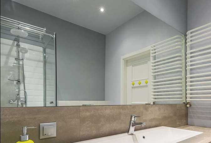 A bathroom with a sink , shower and mirror