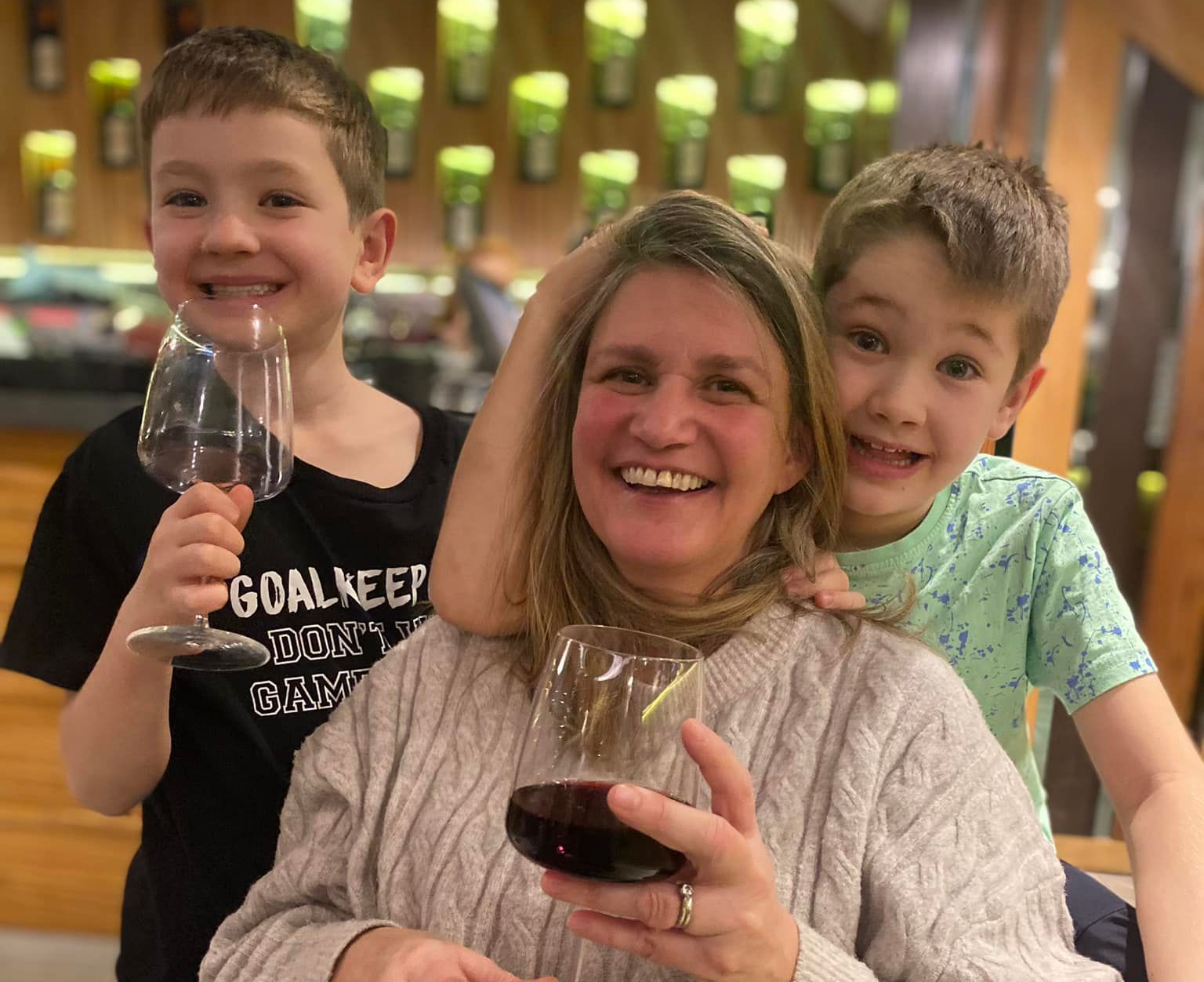 Smiling family toasting with wine glasses in a warmly lit restaurant