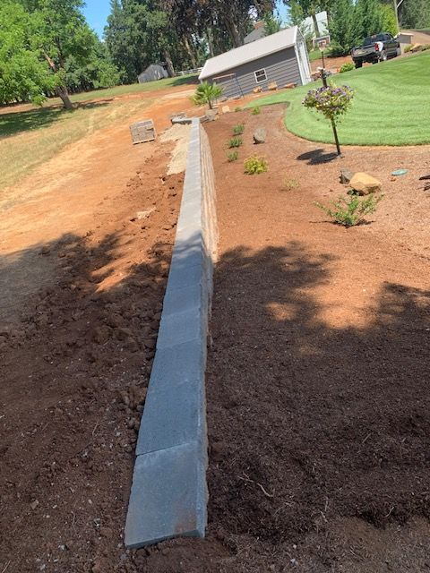New terrace retaining wall construction with fresh mulch and lawn prep in Salem, OR