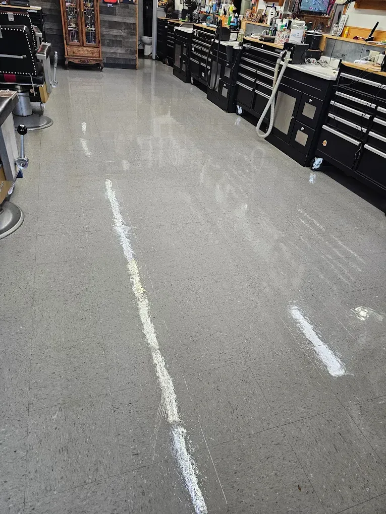 Polished concrete floor in a workshop with black cabinets and tools lining the walls.