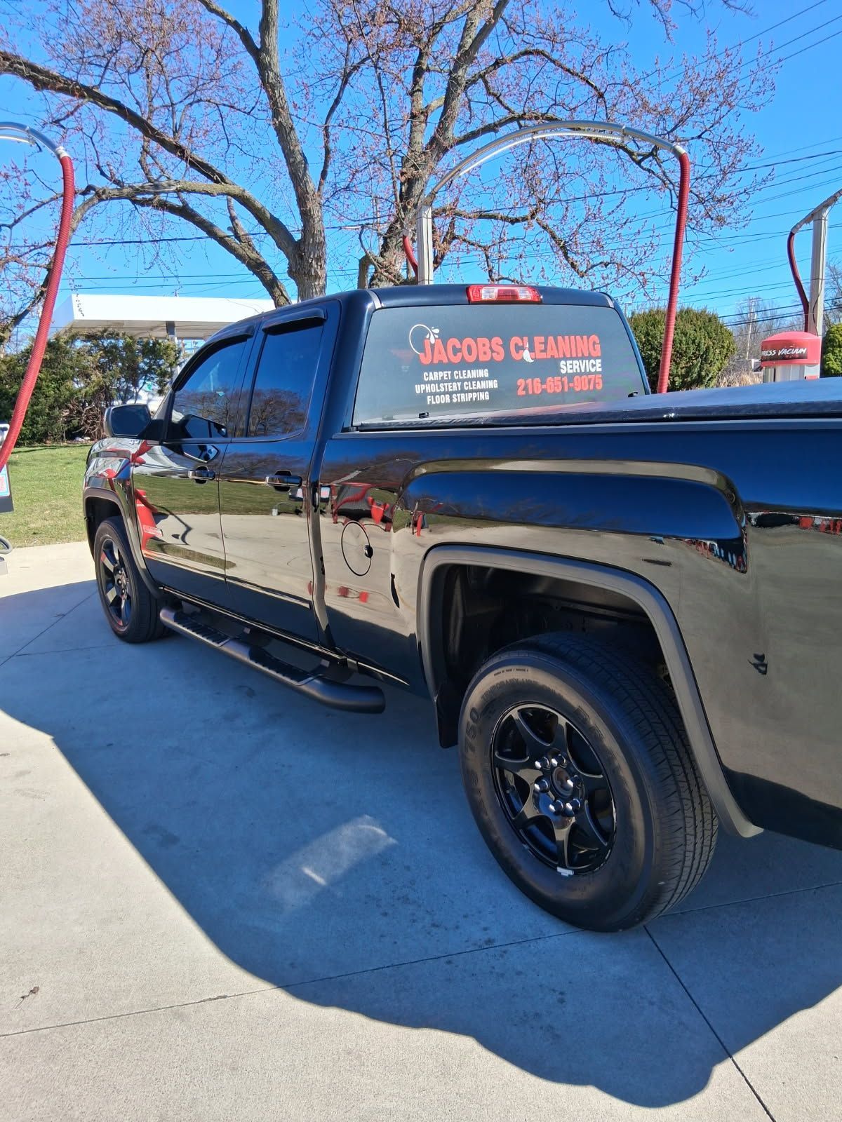 Man wearing pink gloves, holding cleaning supplies, surprised expression.