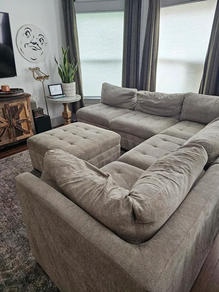 Office cleaning crew using sprayers, wearing blue aprons and gloves, in an office.