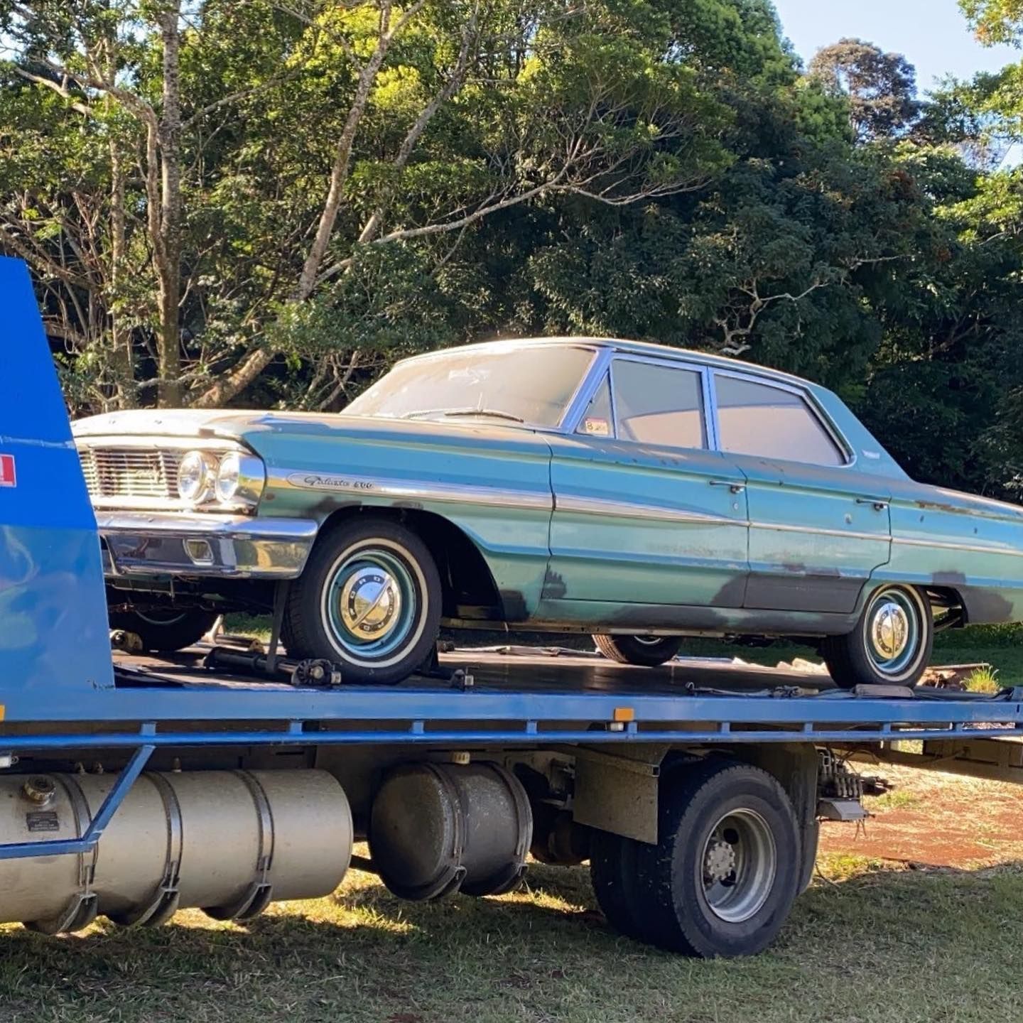 A vintage teal sedan car on a flatbed tow truck — Bangalow Towing in Bangalow, NSW