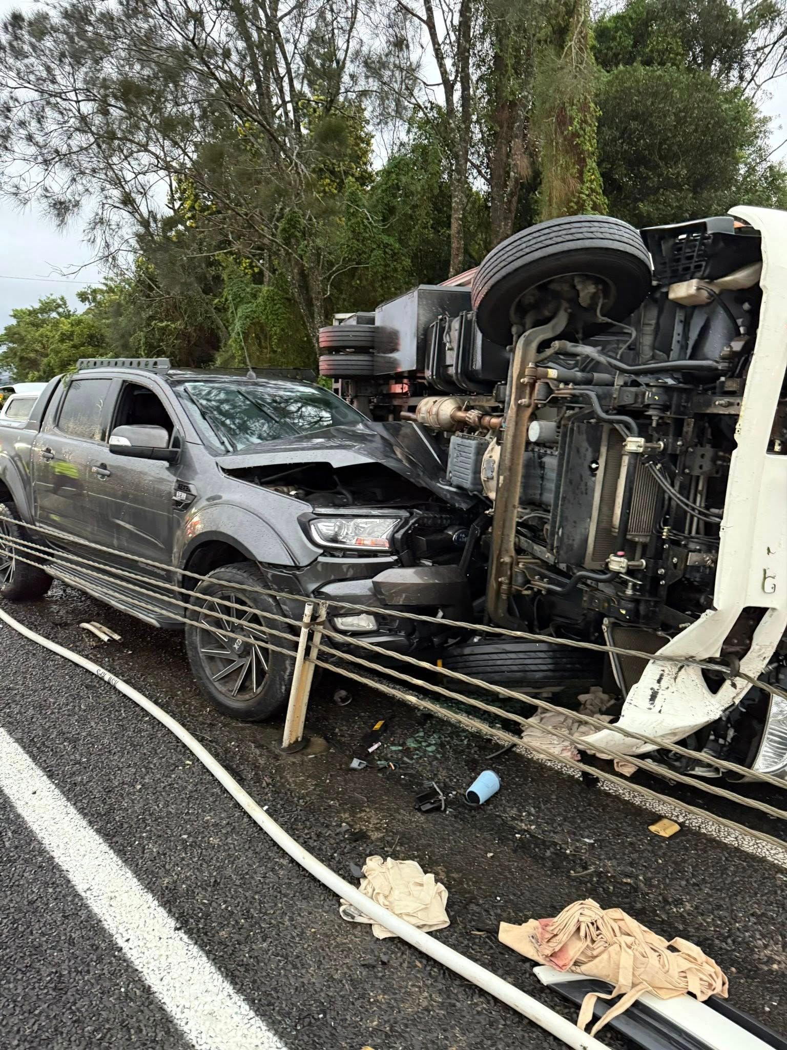 Overturned truck beside crashed gray SUV on a wet roadside — Bangalow Towing in Bangalow, NSW