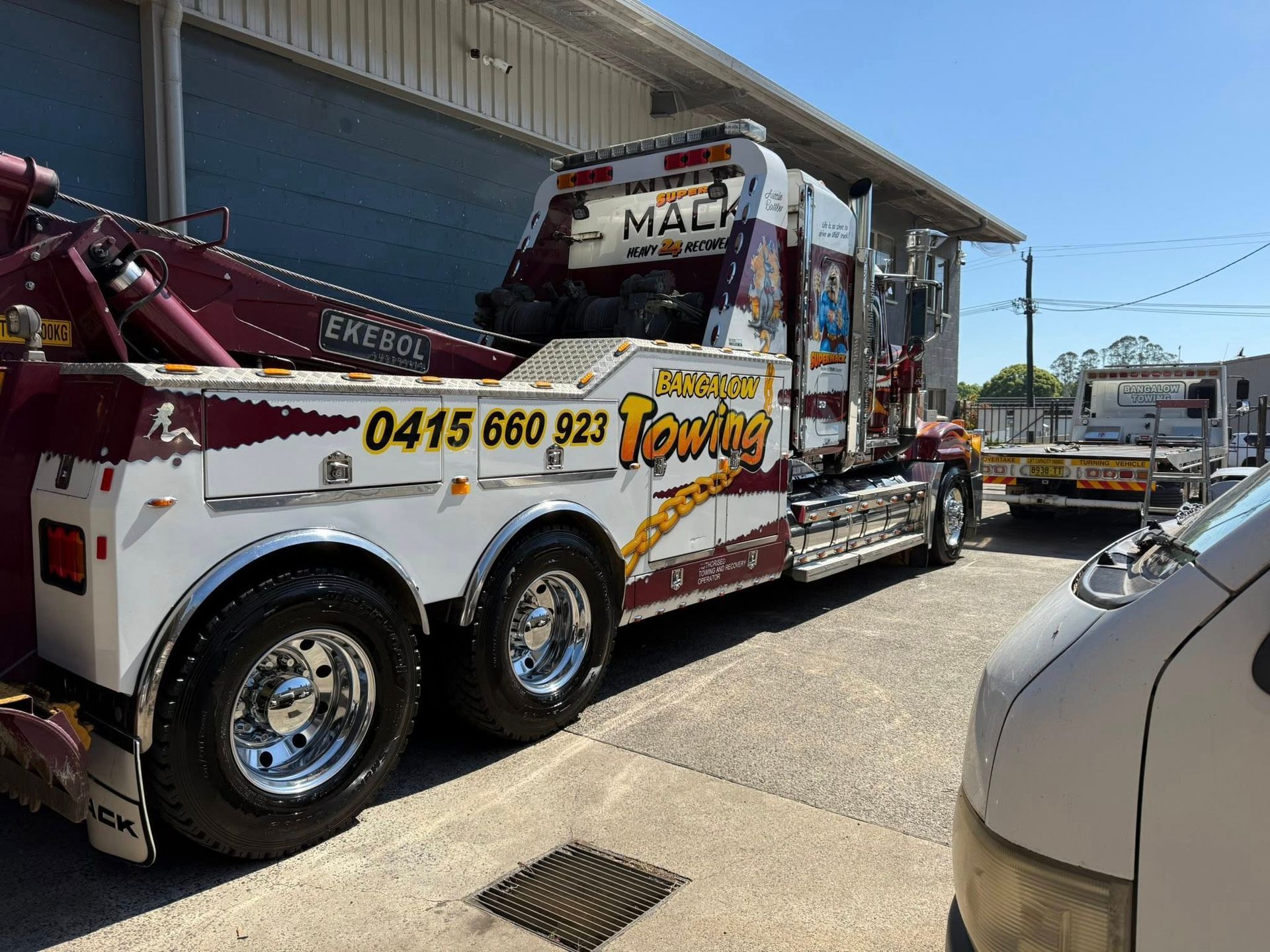 Tow truck with red and white detailing, parked next to a building — Bangalow Towing in Bangalow, NSW