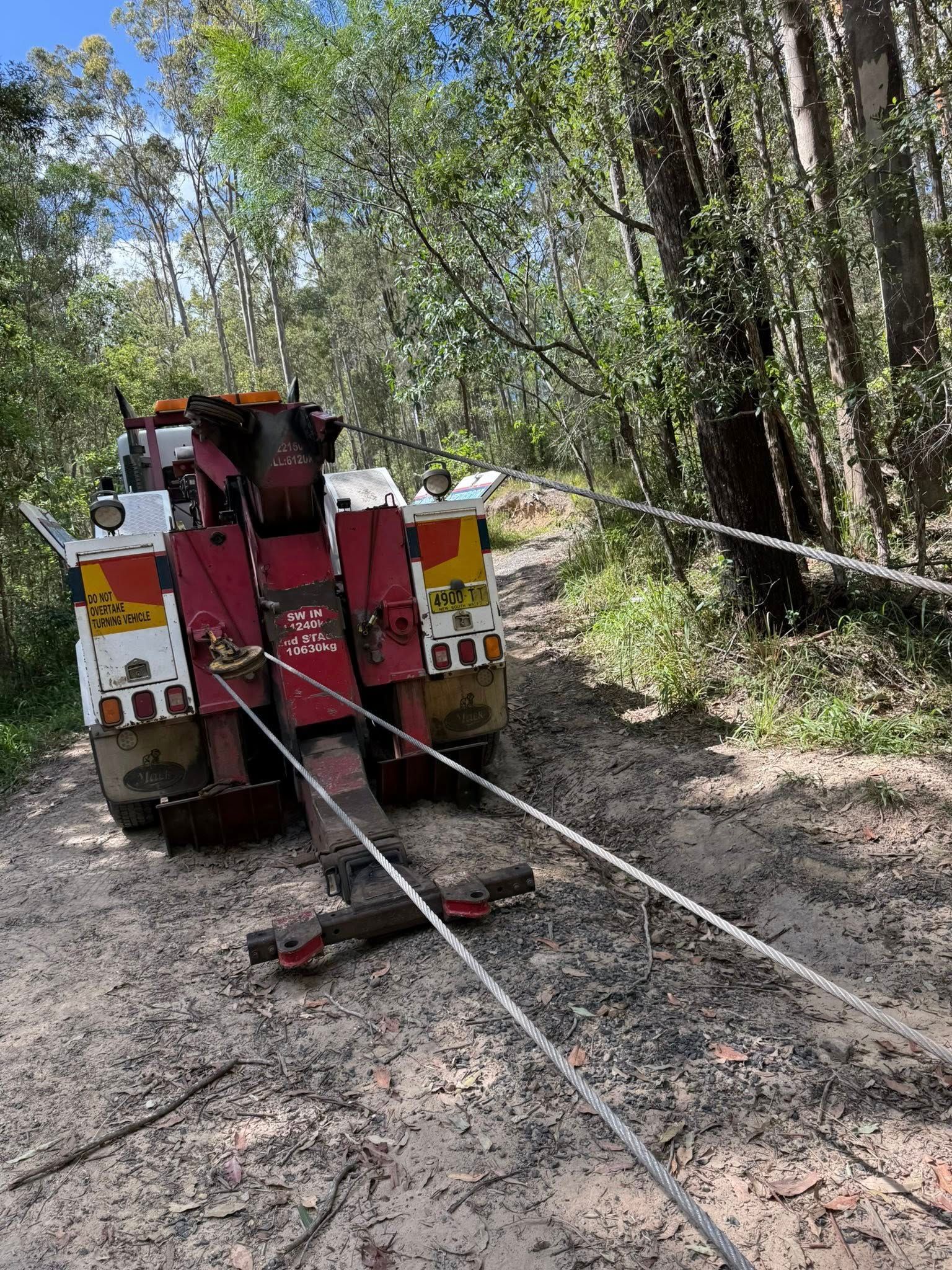 Tow Truck Pulling Vehicle Along a Dirt Track — Bangalow Towing in Bangalow, NSW