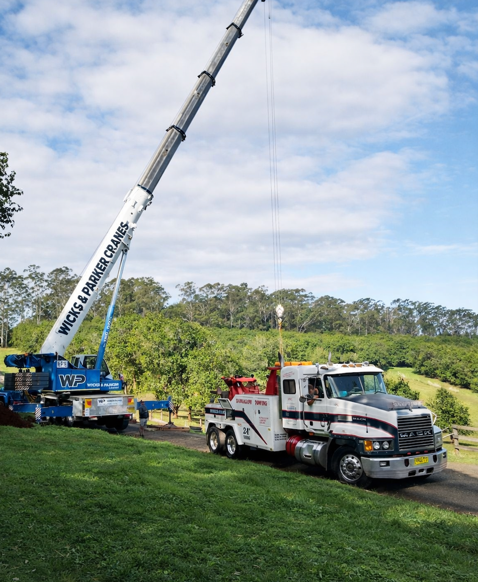 Tow truck and crane beside a grassy field under a blue sky — Bangalow Towing in Bangalow, NSW