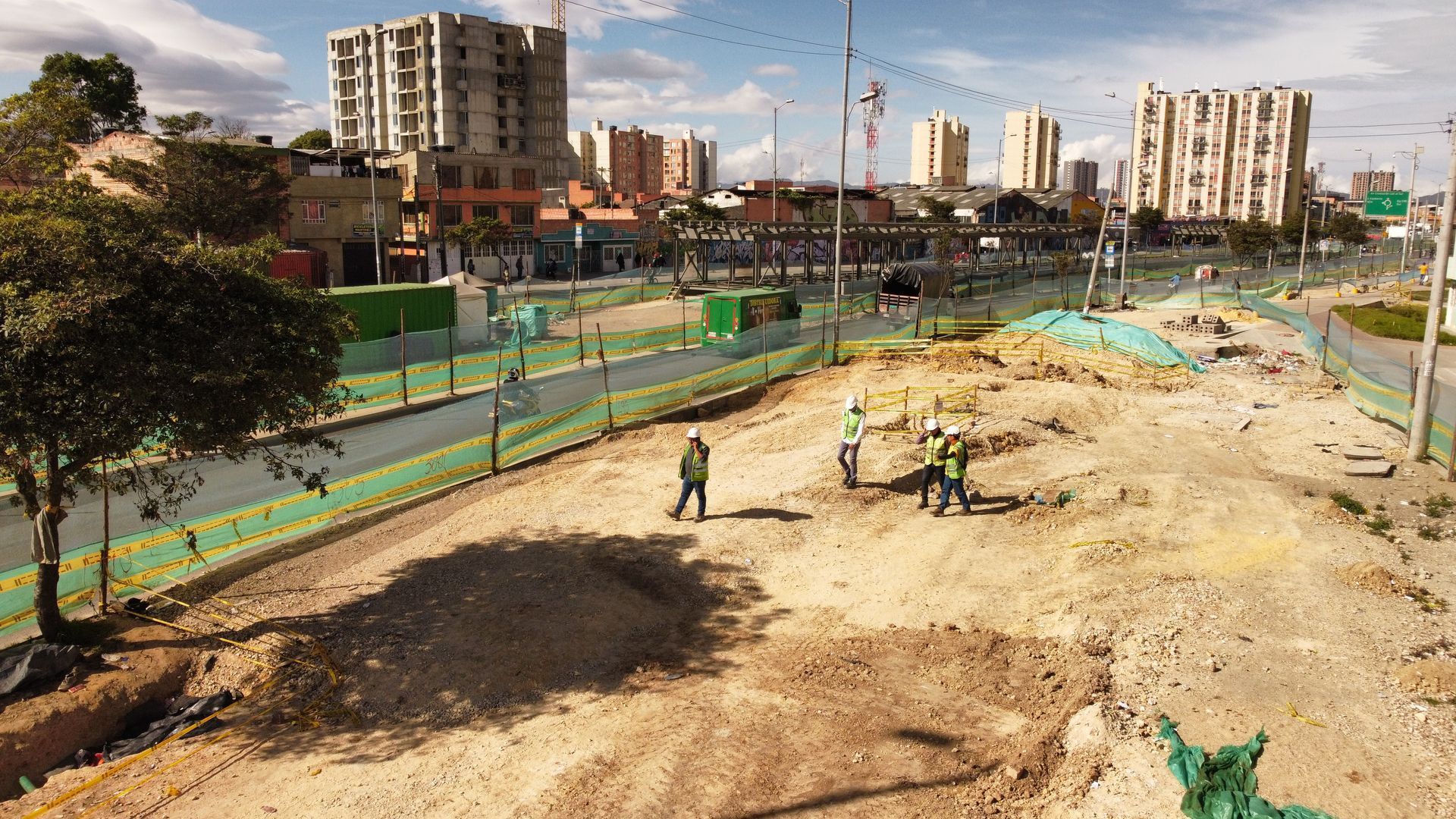 Una vista aérea de un sitio de construcción con una ciudad al fondo.