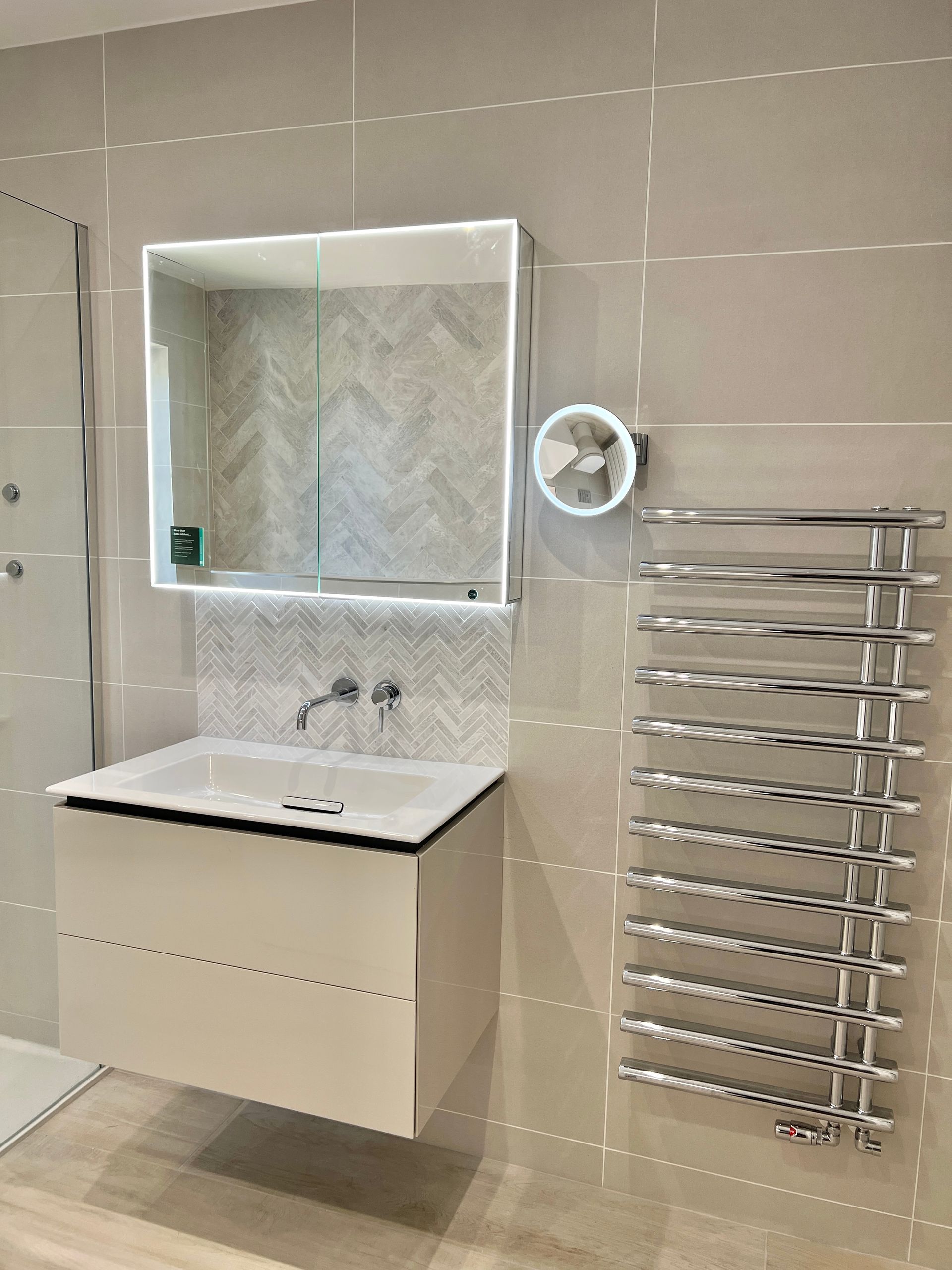 A bathroom with a sink , mirror and towel rack.