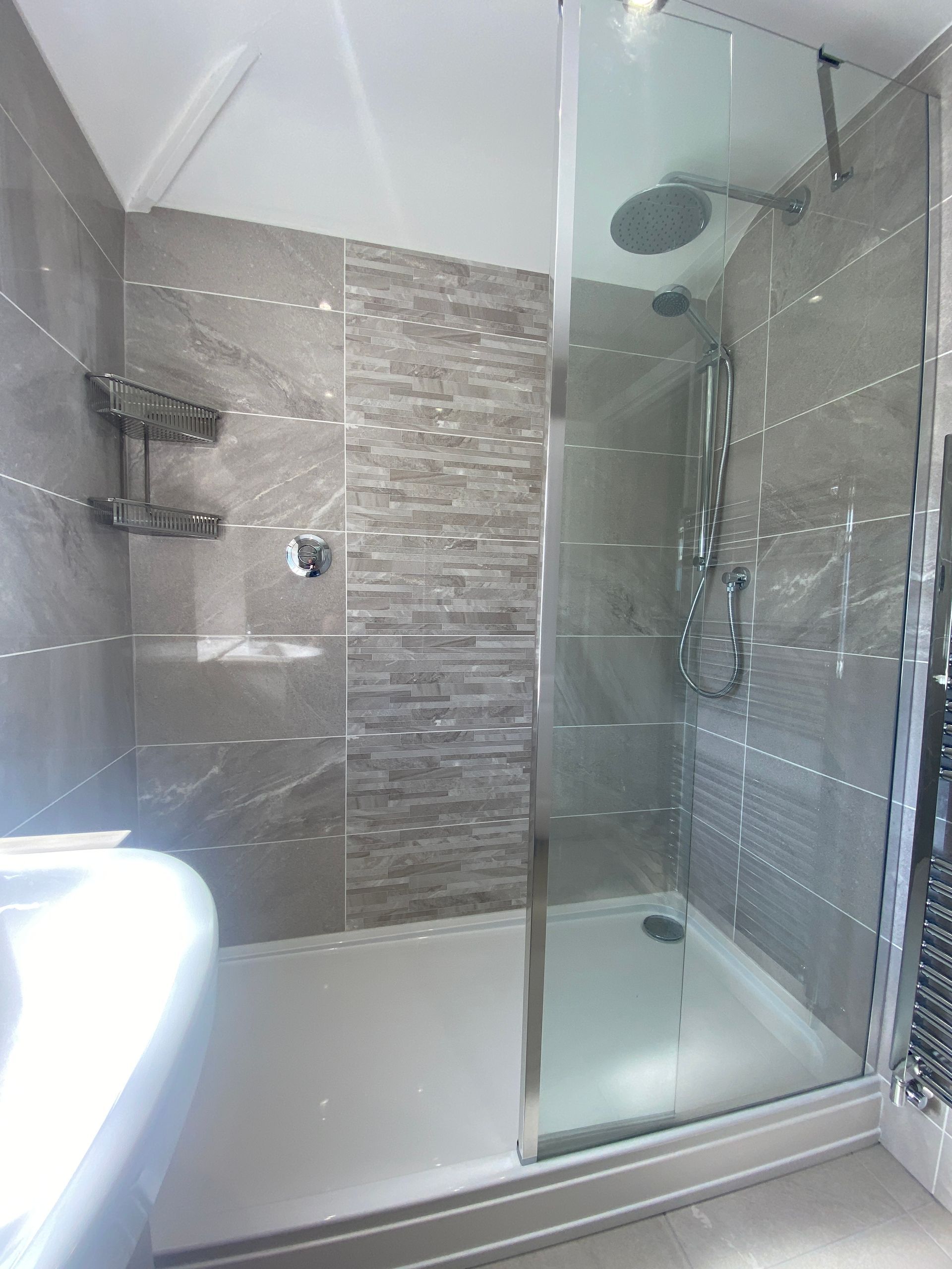 A bathroom with a walk in shower and a sink