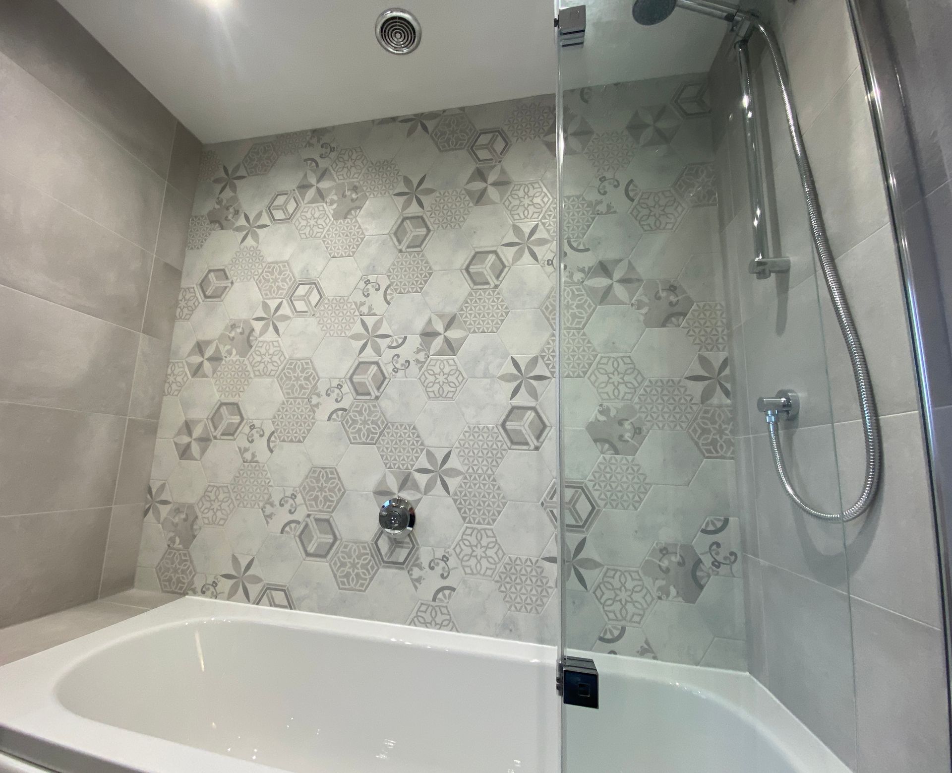 A bathroom with a bathtub and a shower stall.