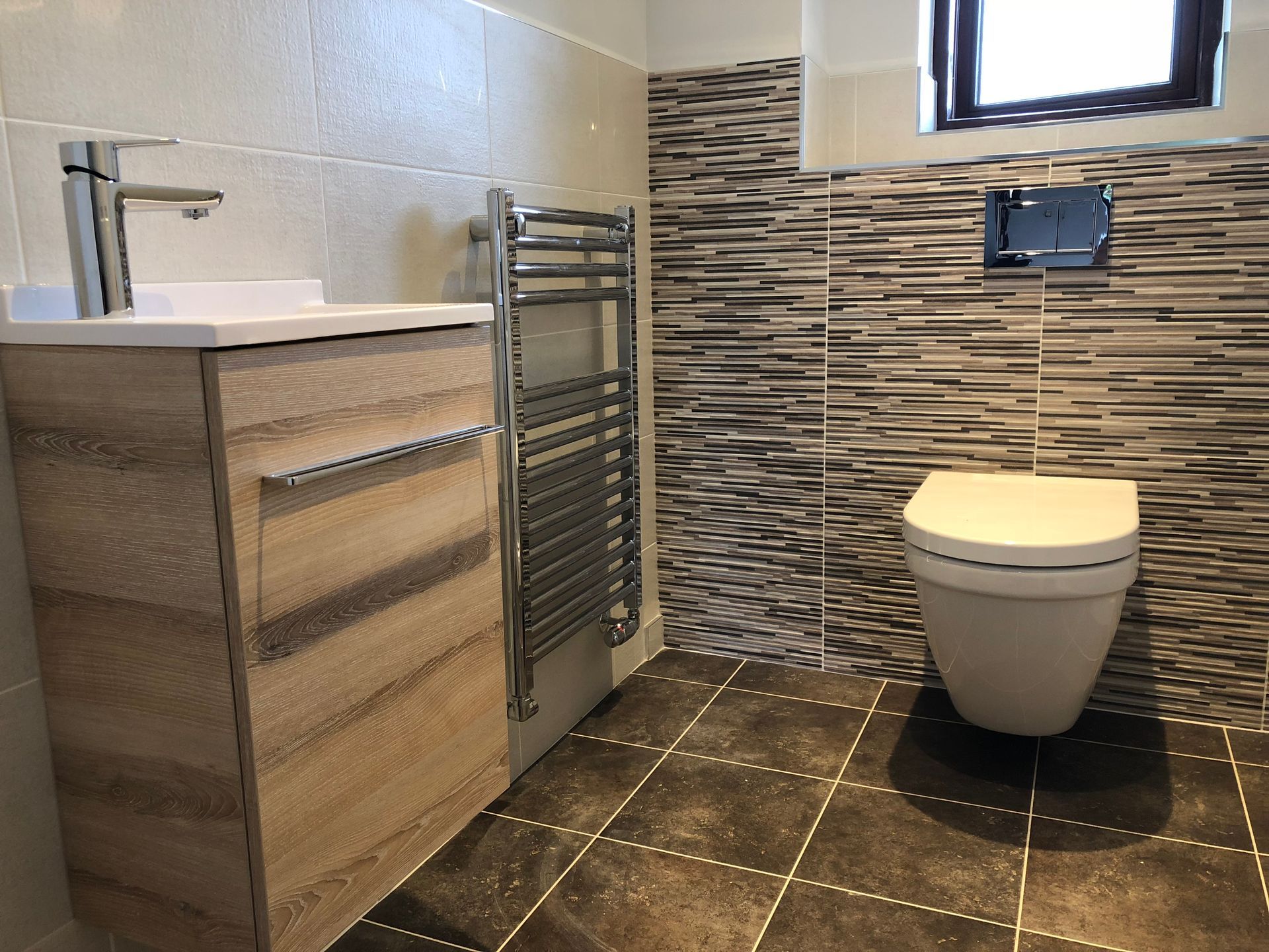 A bathroom with a toilet , sink , and towel rack.