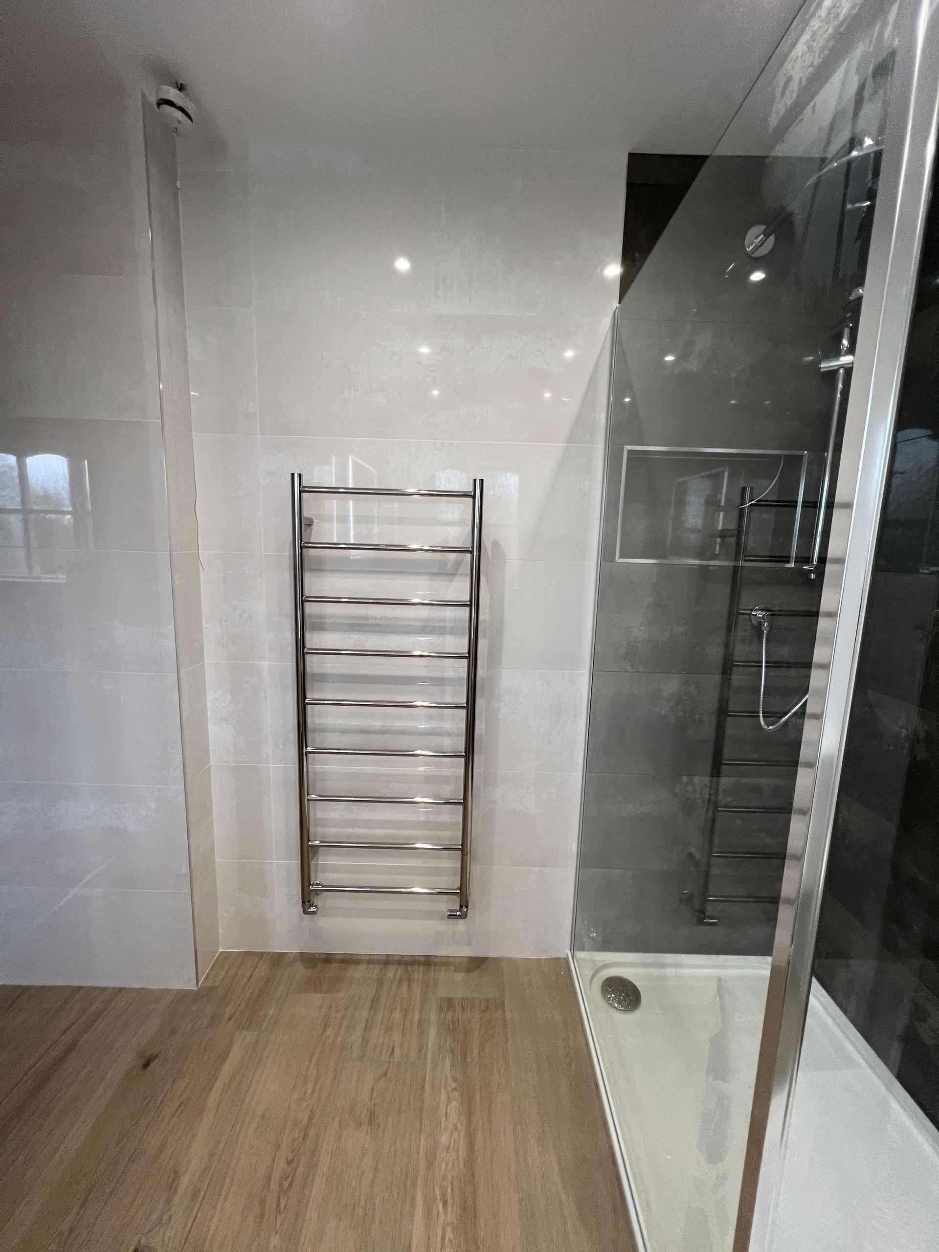 A bathroom with a towel rack and a walk in shower.