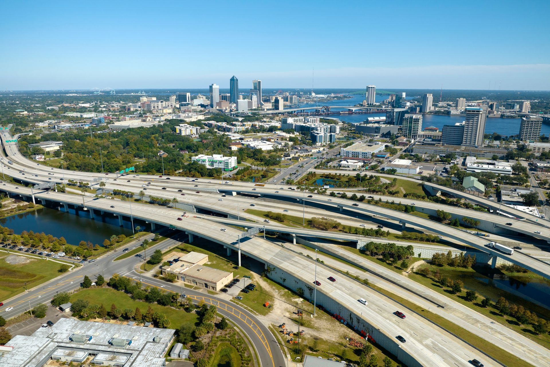 An aerial view of a highway intersection with a city in the background.