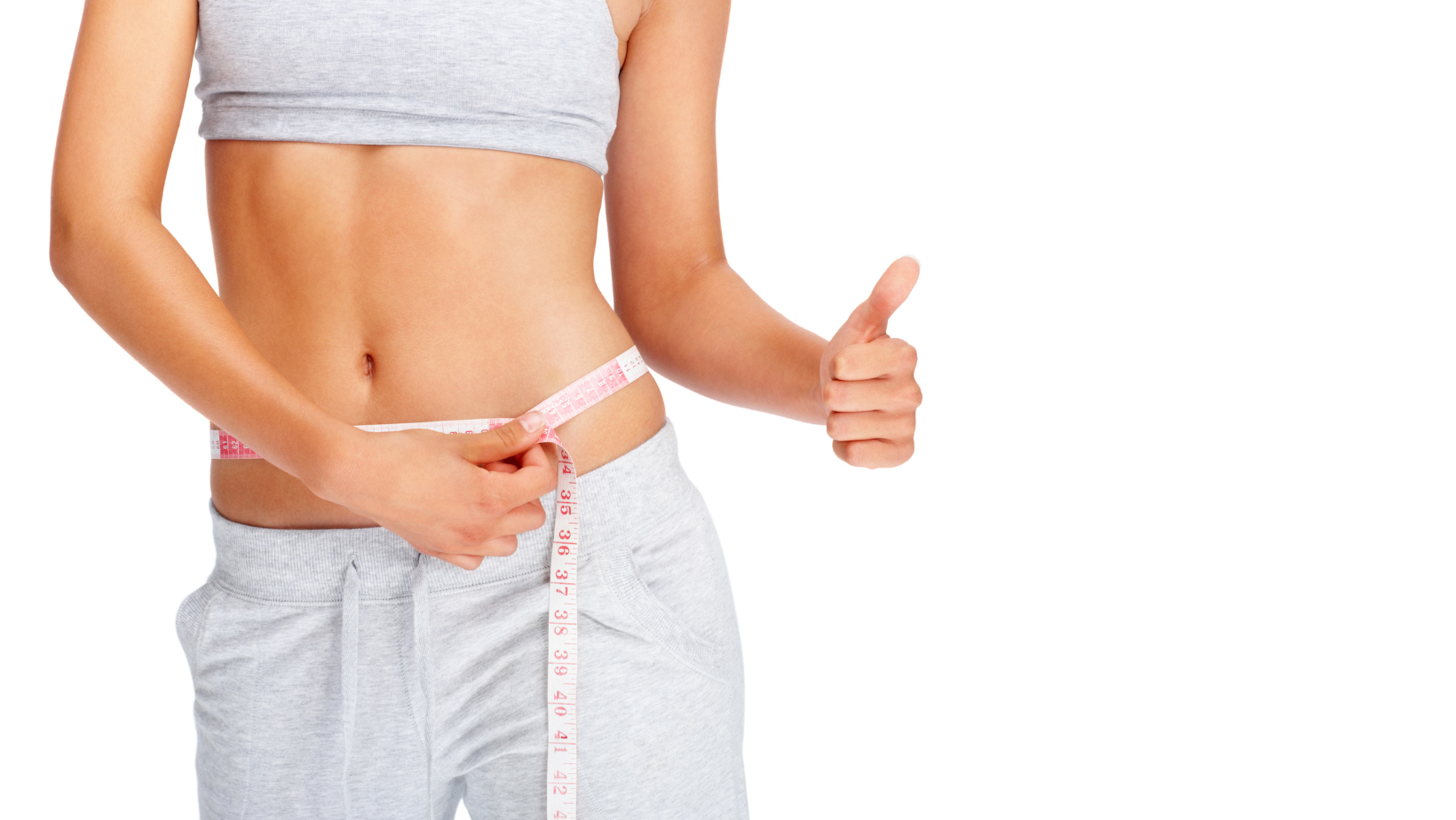 women with flat belly holding measuring tape. 
